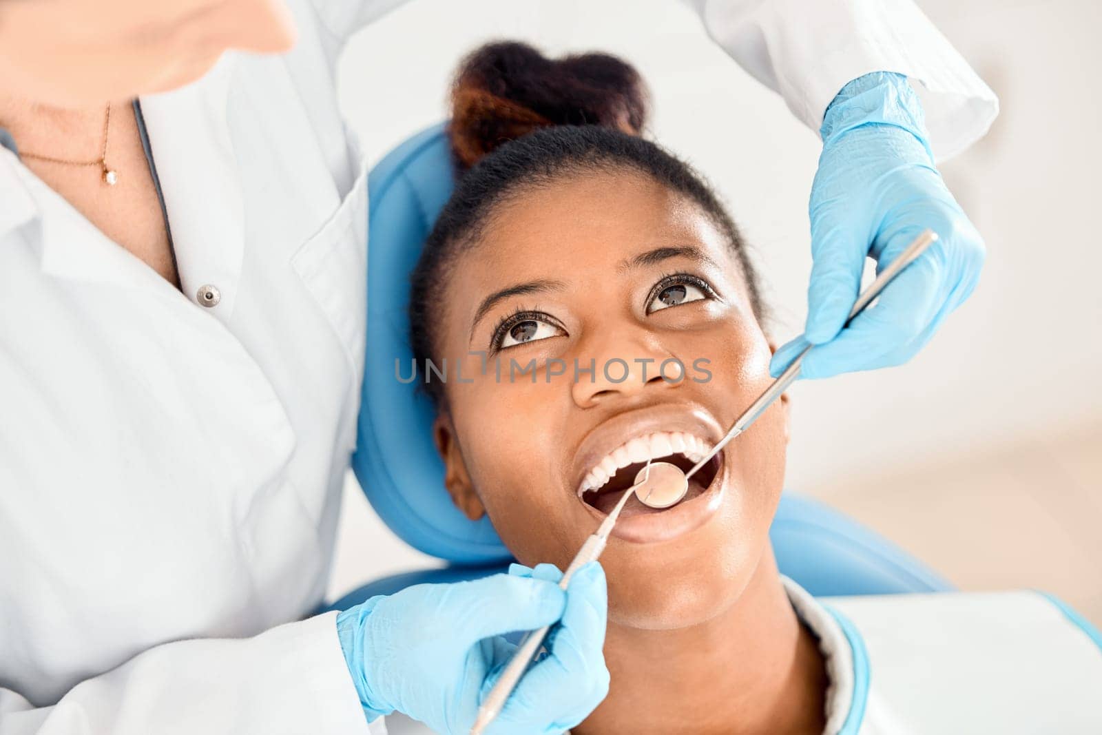 Dentist, black woman and mouth cleaning of patient at a clinic with medical and healthcare for teeth. Mirror, orthodontist and African female person with wellness and dental work tool with care.
