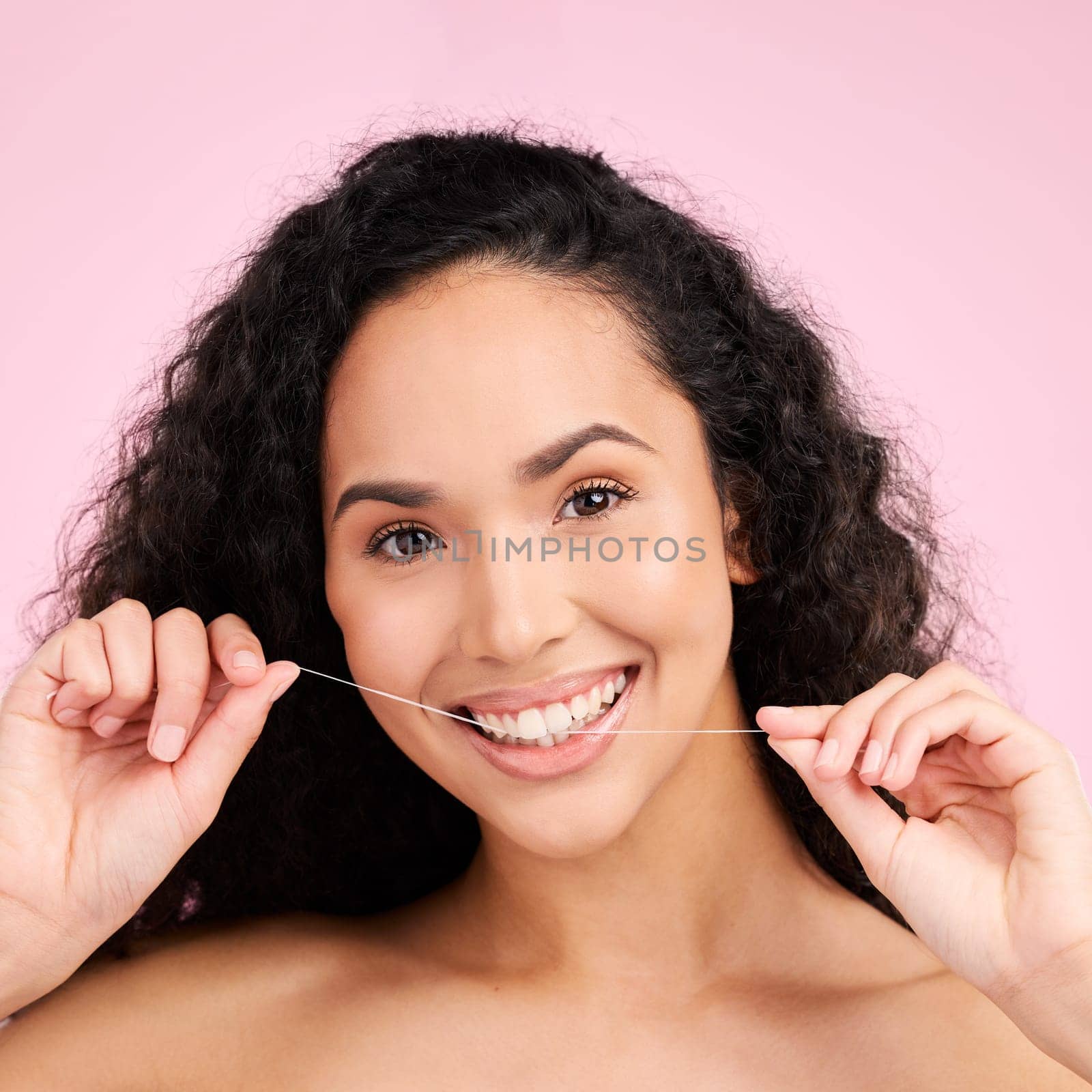 Woman, dental flossing and studio portrait with smile, cleaning and self care for beauty by pink background. Girl, model and string for mouth, teeth whitening and happy for healthy gums with product by YuriArcurs