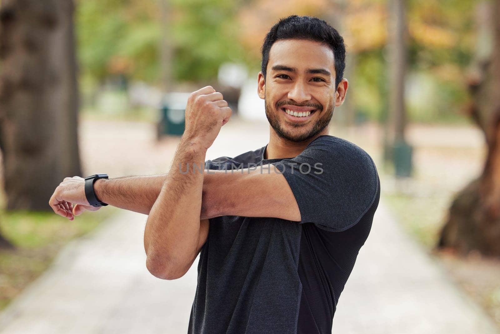 Happy asian man, portrait and stretching arms in fitness getting ready for running, workout or exercise at the park. Male person or runner with smile in warm up arm stretch, training or run in nature by YuriArcurs