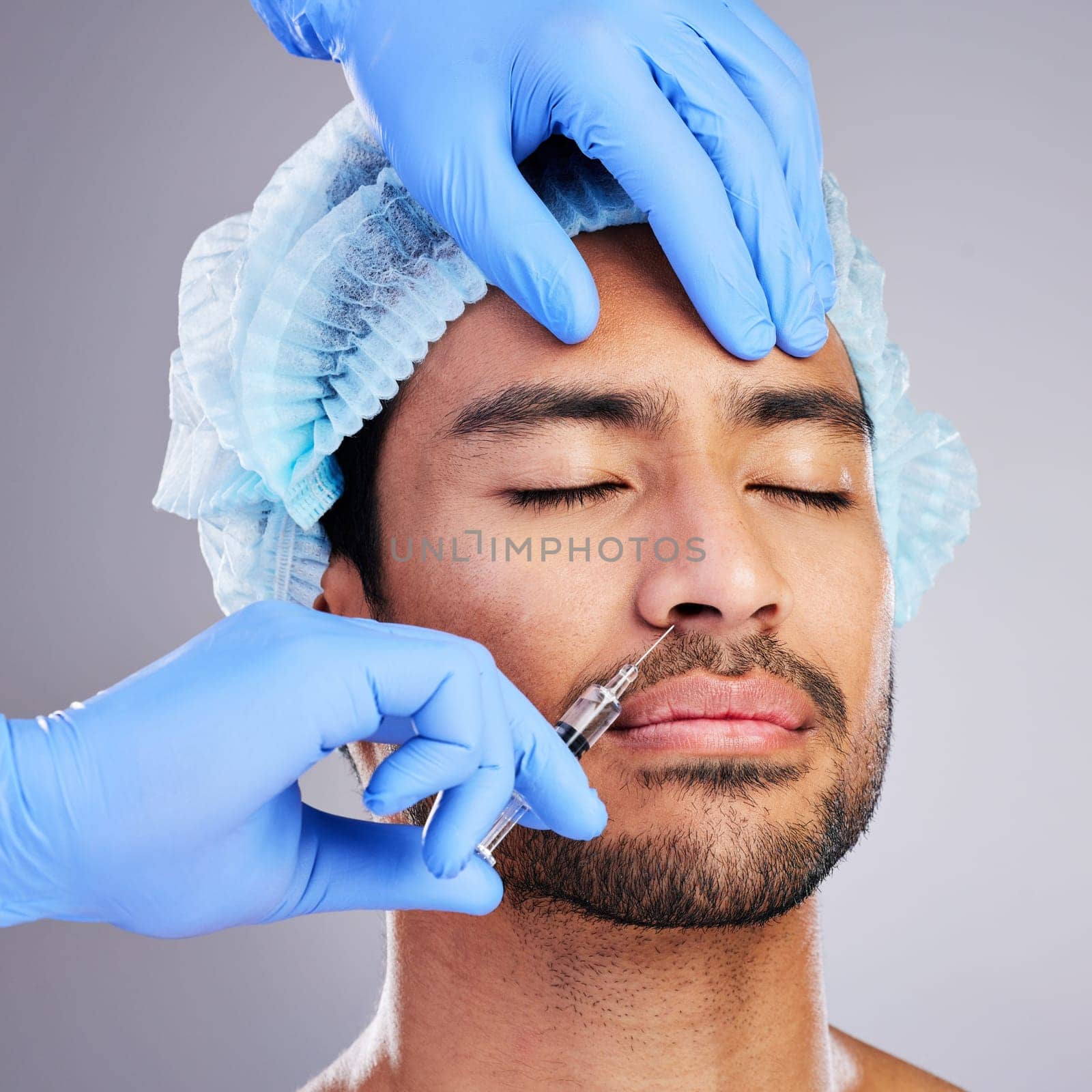 Hands, facelift and plastic surgery with a man in studio on a gray background for a botox injection. Face, change and transformation with a male customer in a clinic for beauty or antiaging filler by YuriArcurs