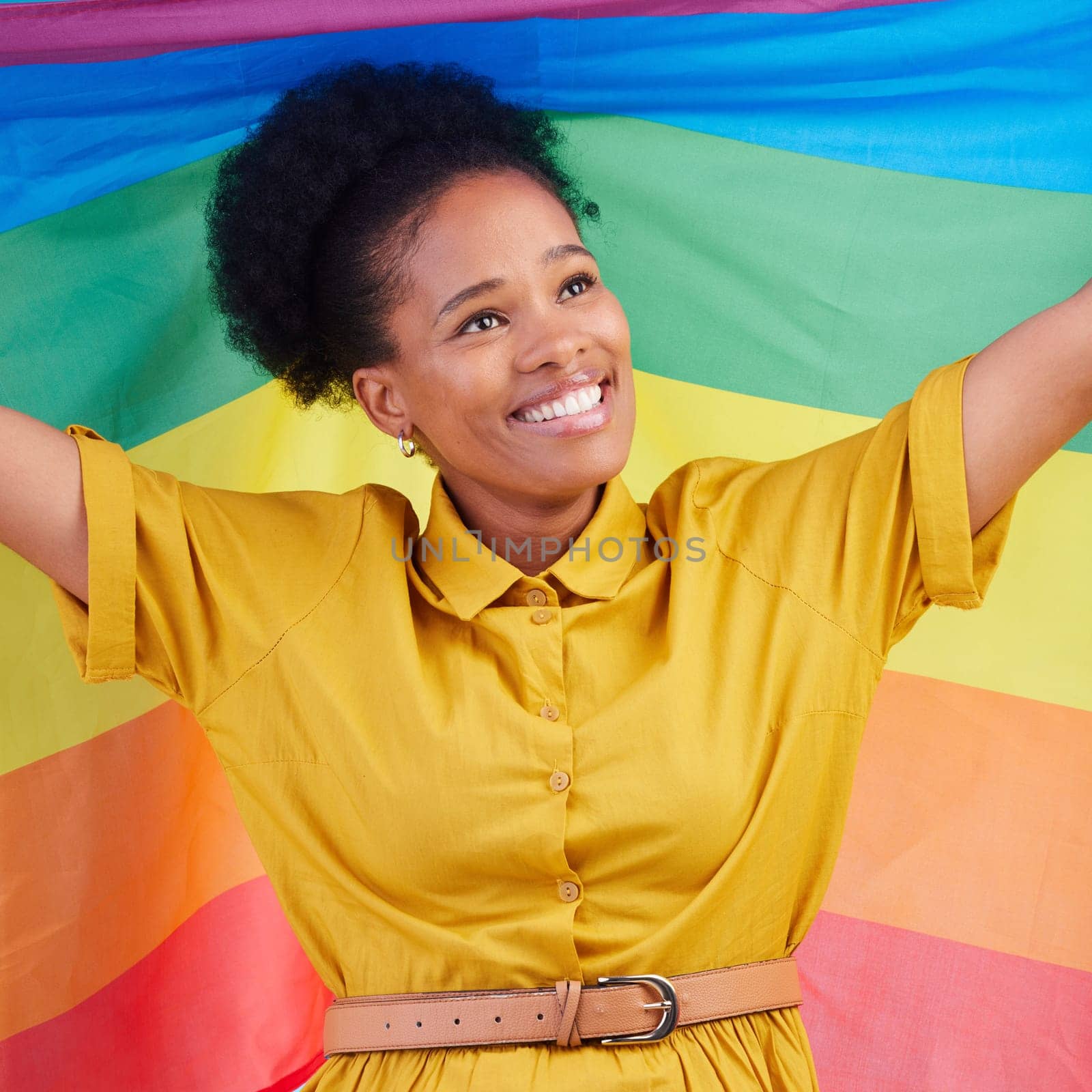 Gay, flag and happy black woman in studio for pride, rights and lgbtq lifestyle choice. Rainbow, freedom and face of lesbian African female smile, free and confident with queer sexuality or identity.