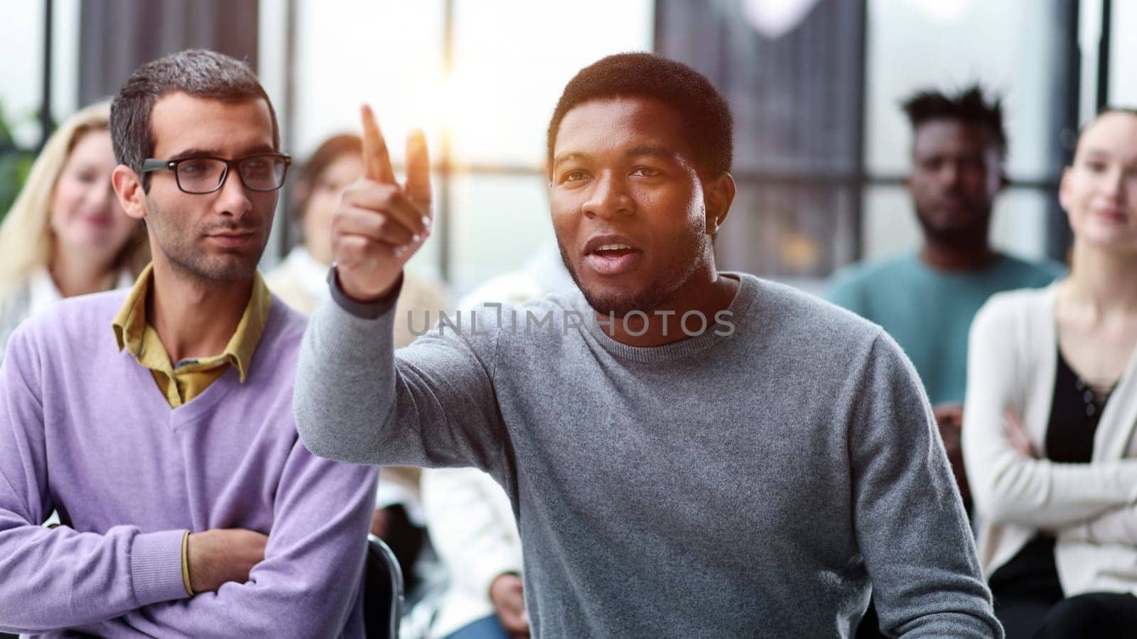 African American business man raise their hand at the conference to answer a question