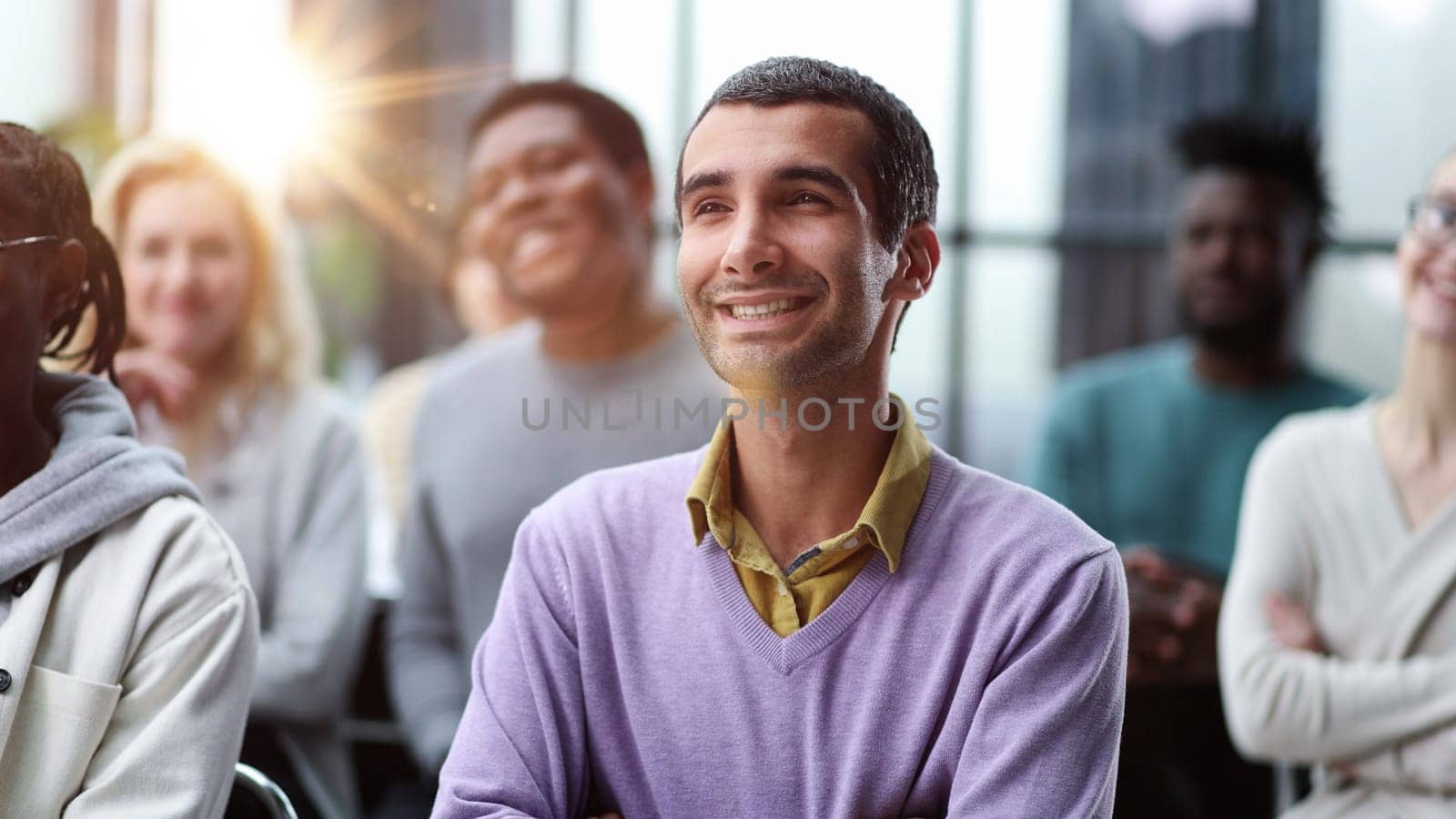 Group of happy interested business people listening to a colleague during a meeting