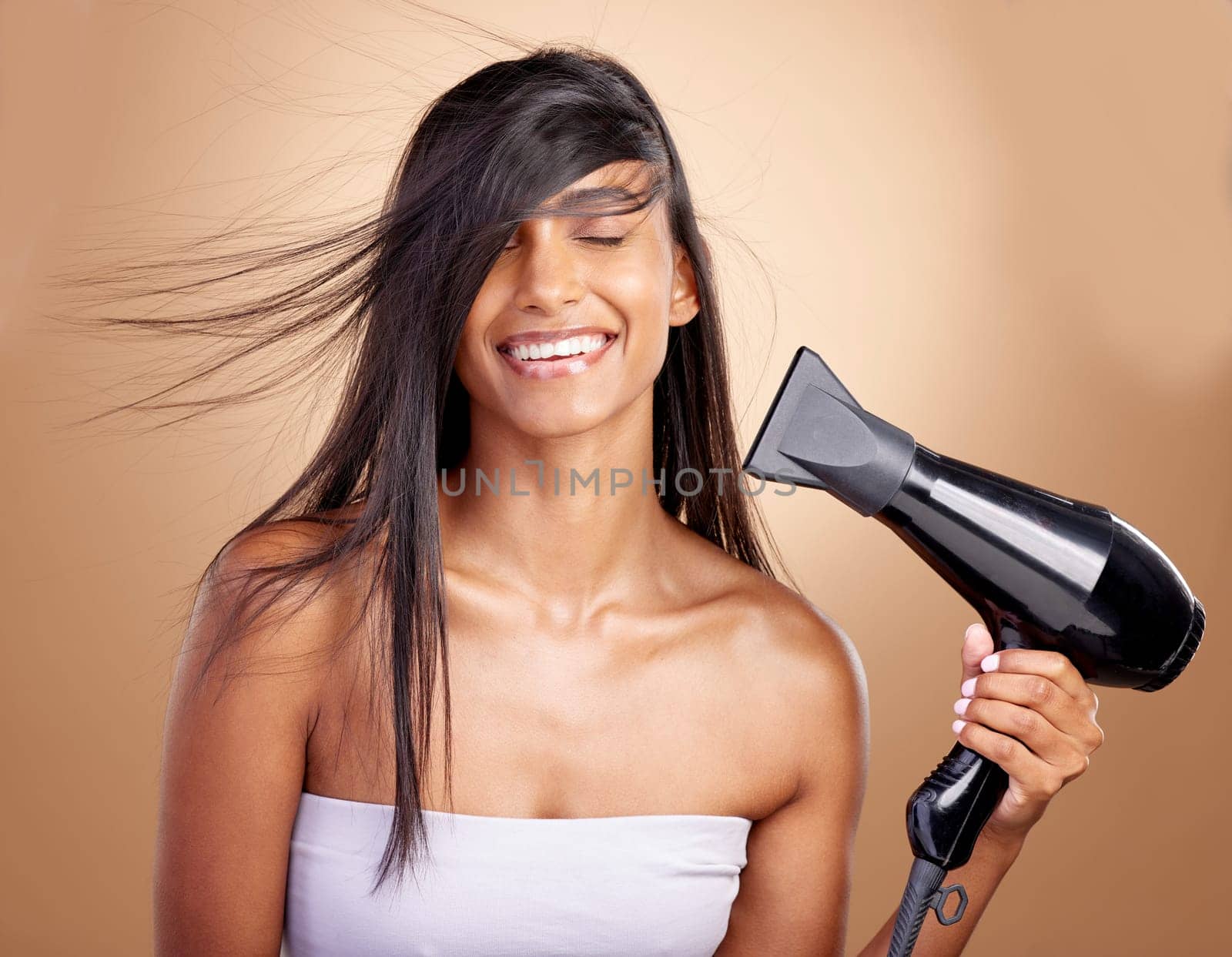 Hairdryer, hair and woman, beauty and shine, cosmetic care with heat isolated on studio background. Female model smile, haircare and growth, cosmetology and texture with growth and electric appliance by YuriArcurs