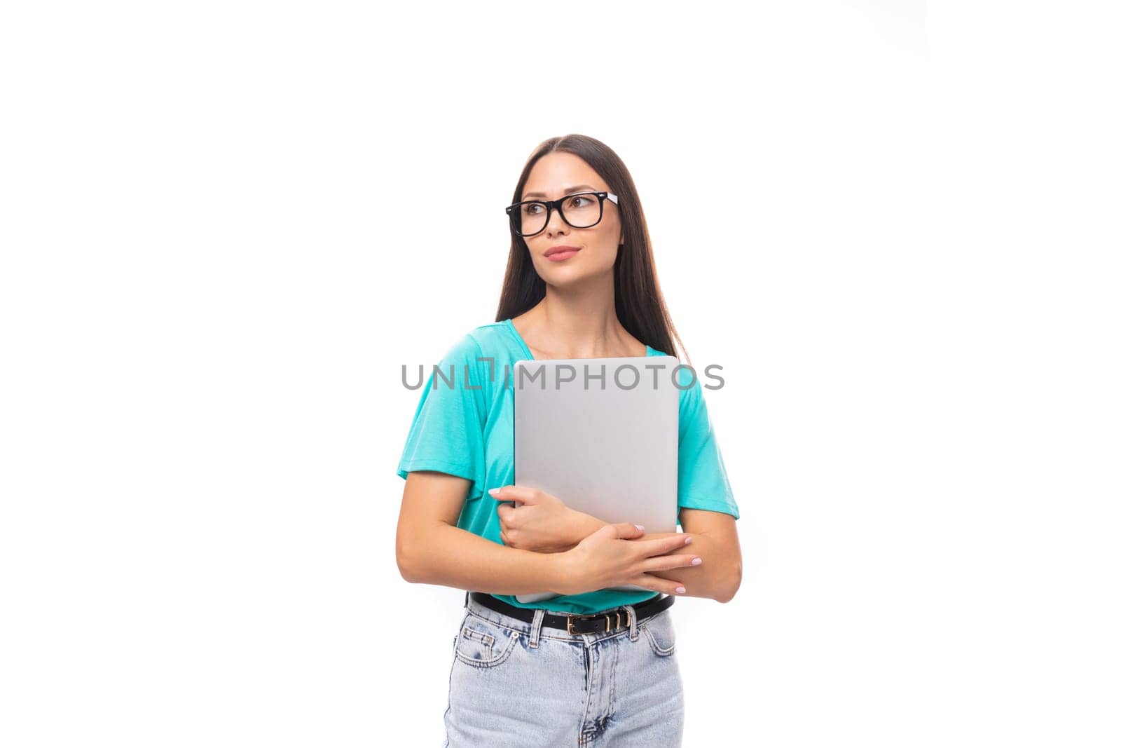 young smart caucasian brunette woman with long hair in glasses blue t-shirt works using laptop on white background with copy space.