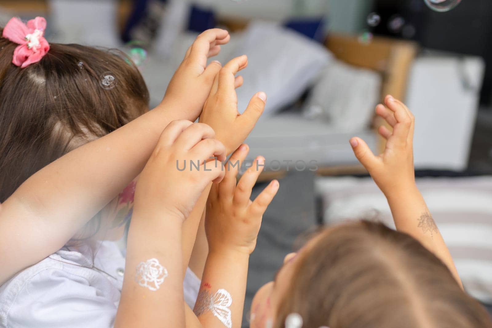 Children catch soap bubbles with their hands at a street party. High quality photo