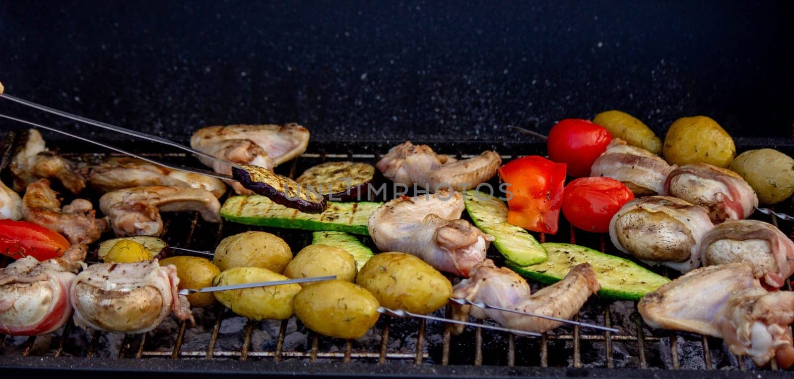 a man is grilling vegetables and meat. Selective focus. Nature