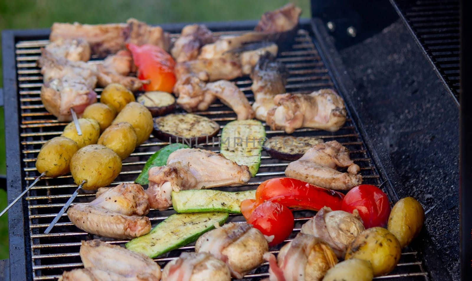 a man is grilling vegetables and meat. Selective focus. Nature