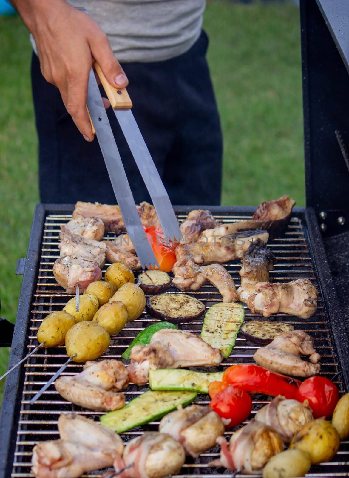 a man is grilling vegetables and meat. Selective focus. Nature