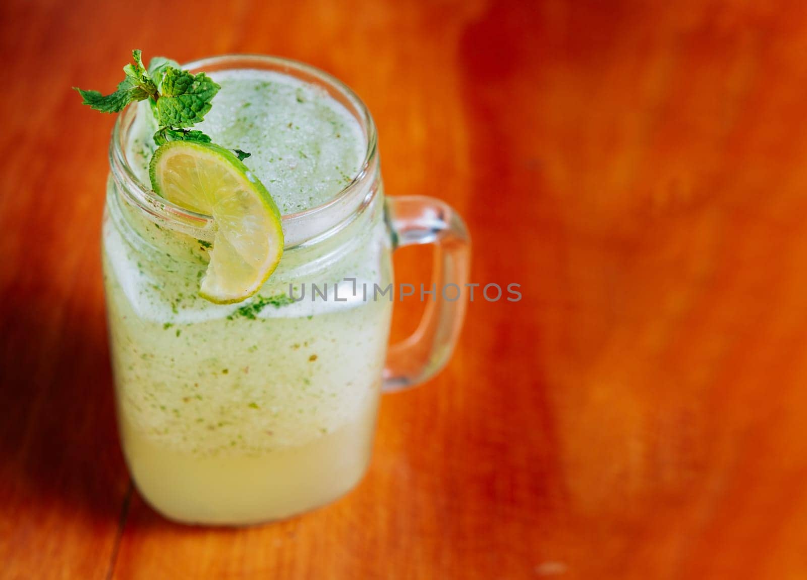 Refreshing lemonade with mint on wooden table. Lemonade drink on wooden table