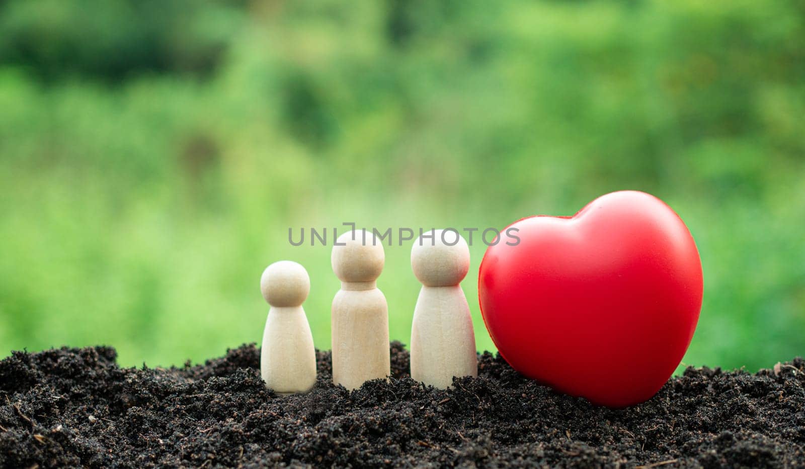 Happy home concept. A family of wooden dolls and a red heart. Indicates happiness and love in the house. by Unimages2527