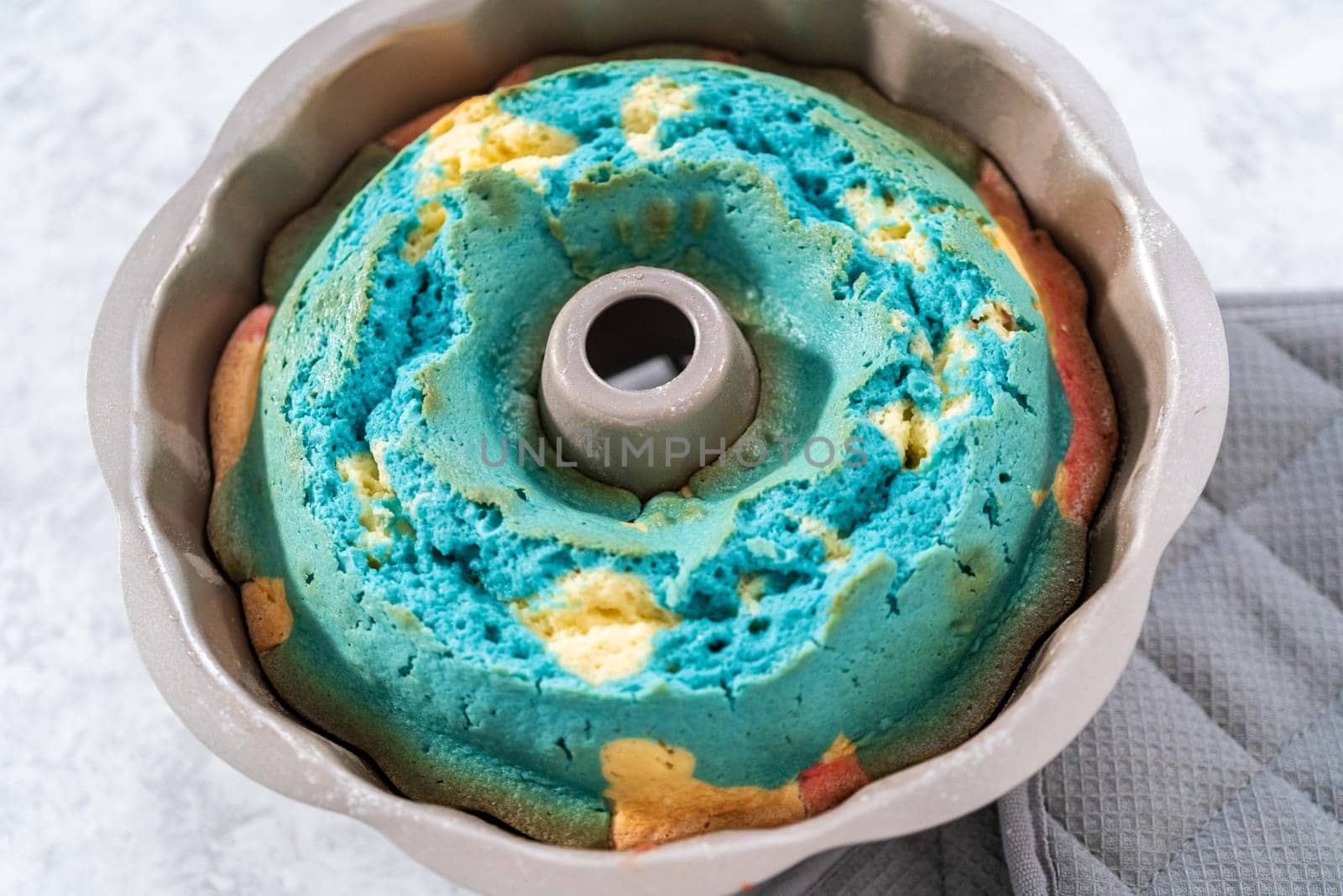 Cooling freshly baked bundt cake in bundt cake pan on the kitchen counter.