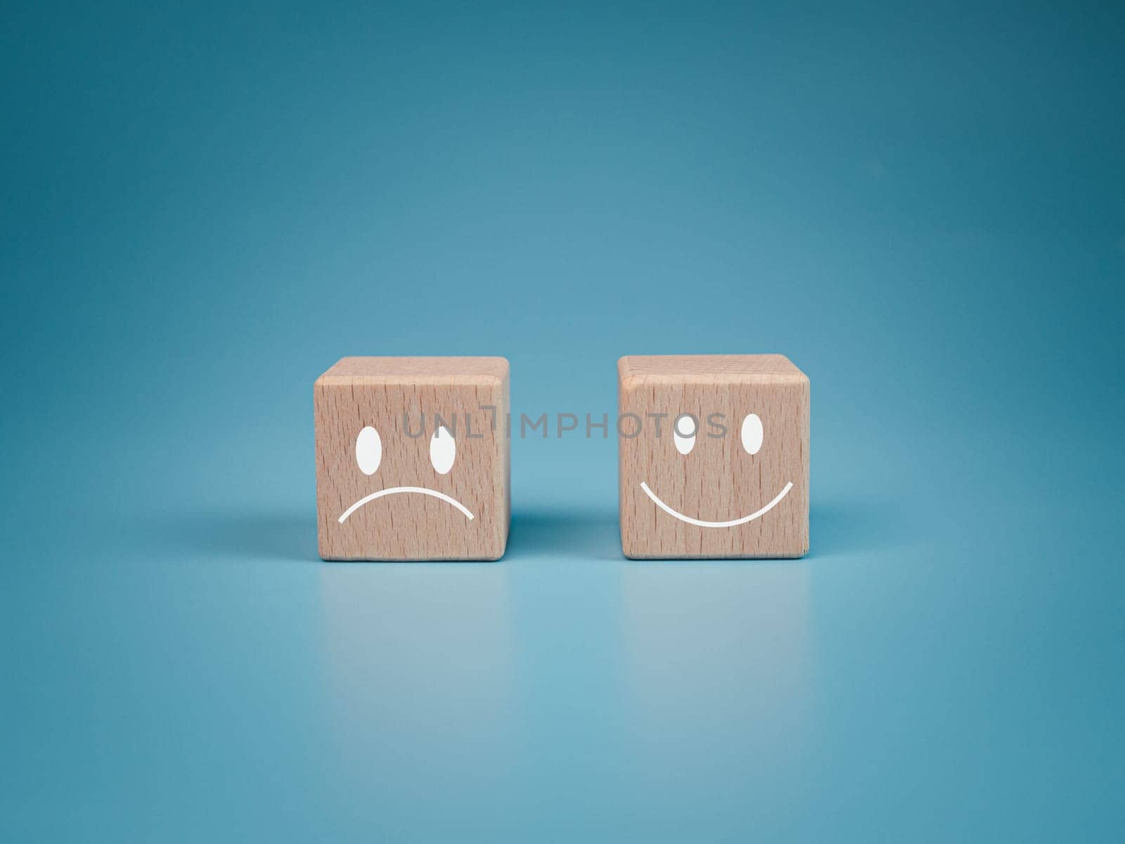 Mental health and emotional state concept, Smile face  and sad face on wooden block cube for positive mindset selection concept. by Unimages2527