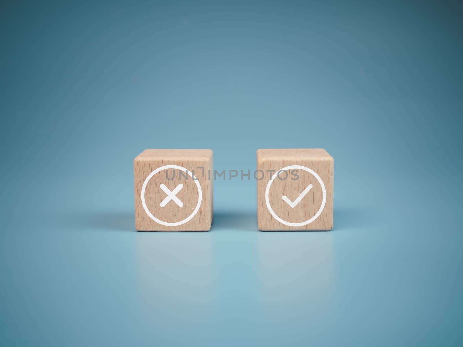 Wooden blocks with wrong and right symbols on light blue background. by Unimages2527