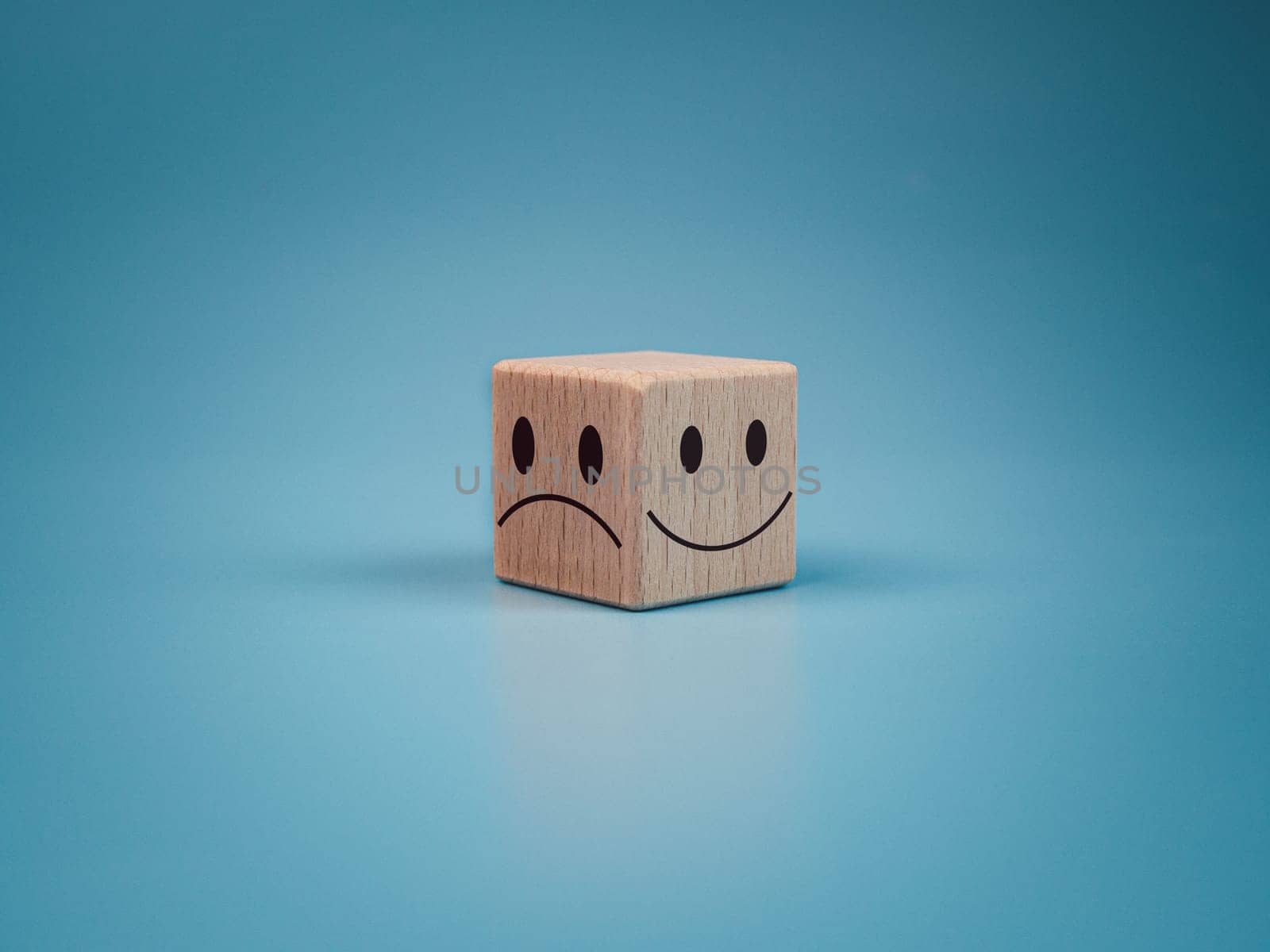 Mental health and emotional state concept, Smile face  and sad face on wooden block cube for positive mindset selection concept. by Unimages2527