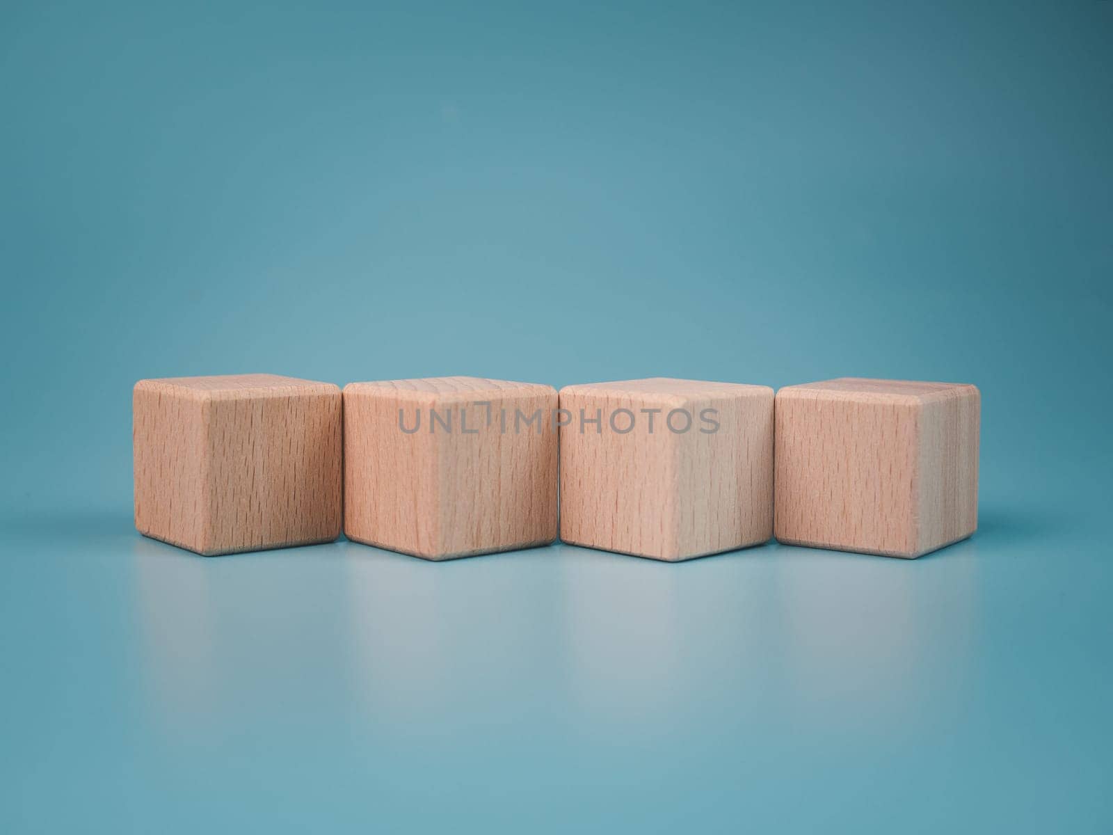 empty wooden blocks lined up on light blue background. Business concept,object. by Unimages2527