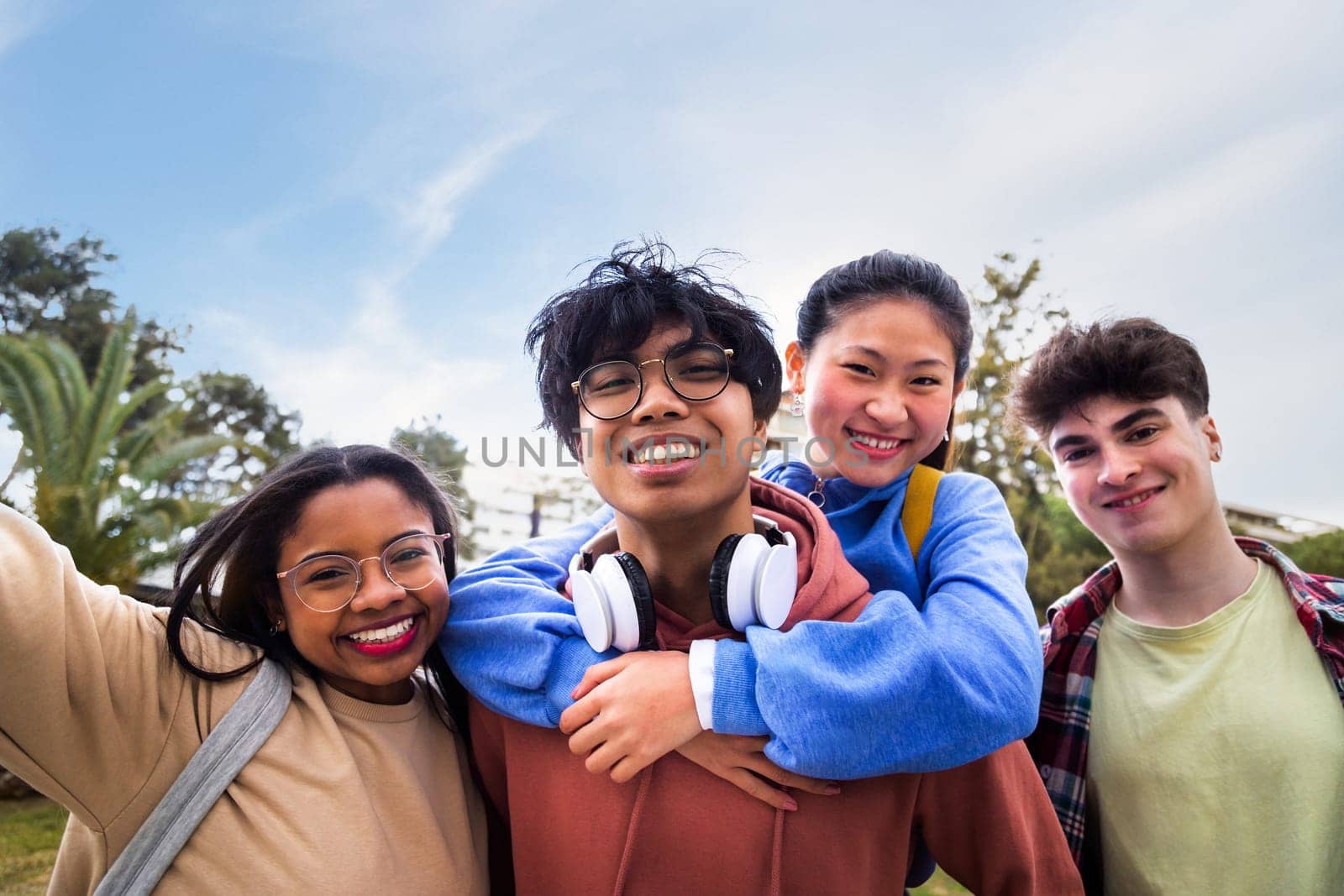 Teenage multiracial happy college students friends having fun taking a selfie looking at camera. Gen z. by Hoverstock