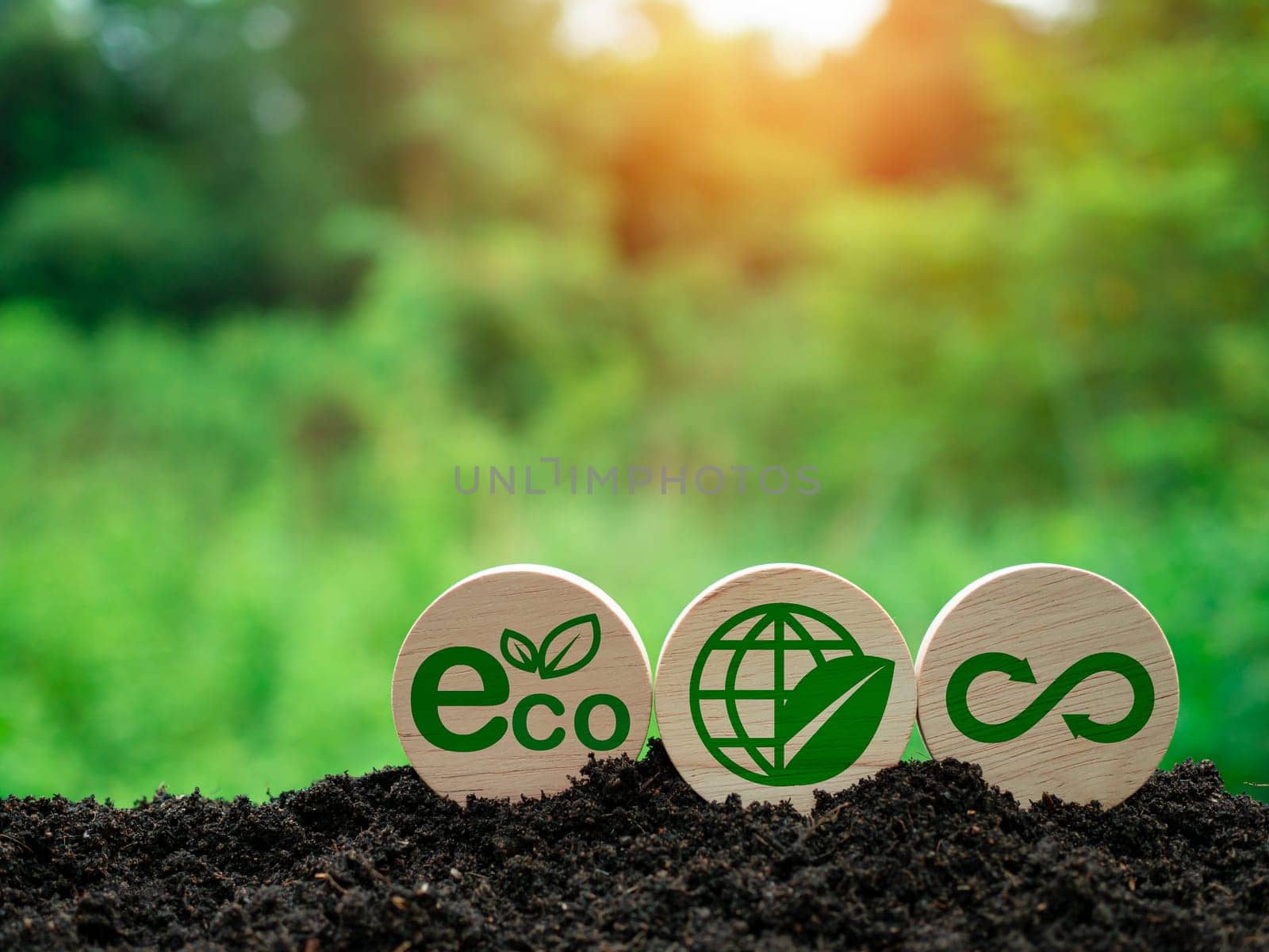 Concepts of waste reduction, pollution, reuse, efficient use of resources. Environmental protection sign by recycling on circular wooden board on nature background.