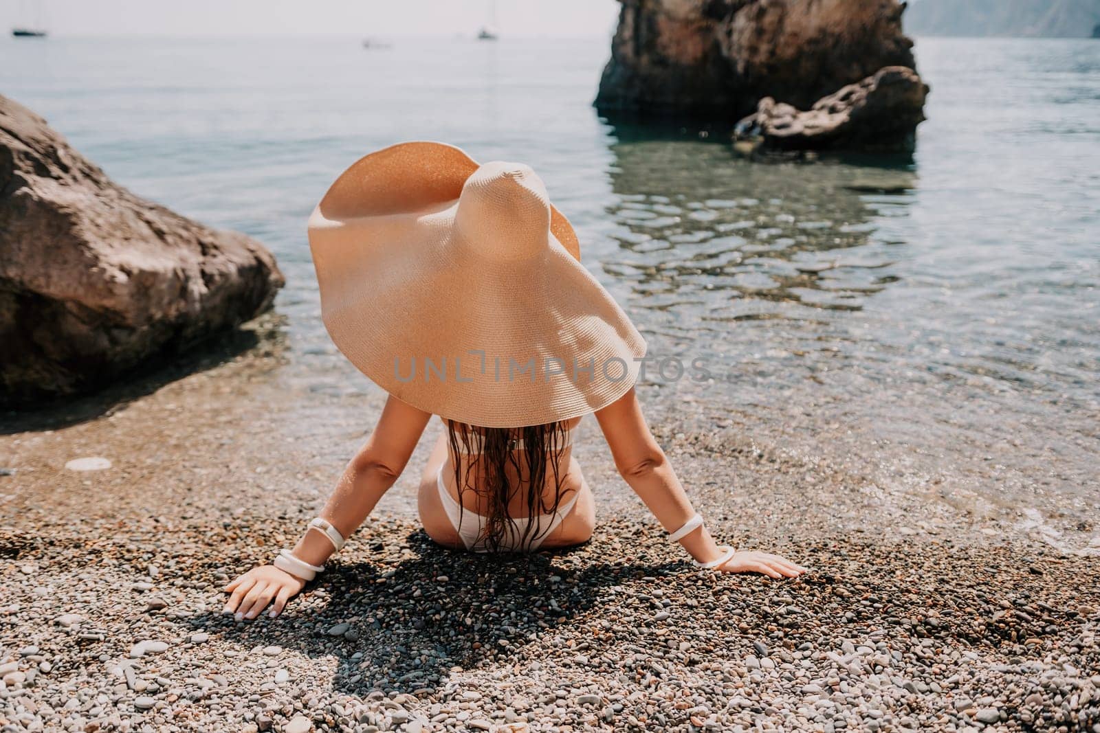 Woman travel sea. Happy tourist in hat enjoy taking picture outdoors for memories. Woman traveler posing on the beach at sea surrounded by volcanic mountains, sharing travel adventure journey by panophotograph