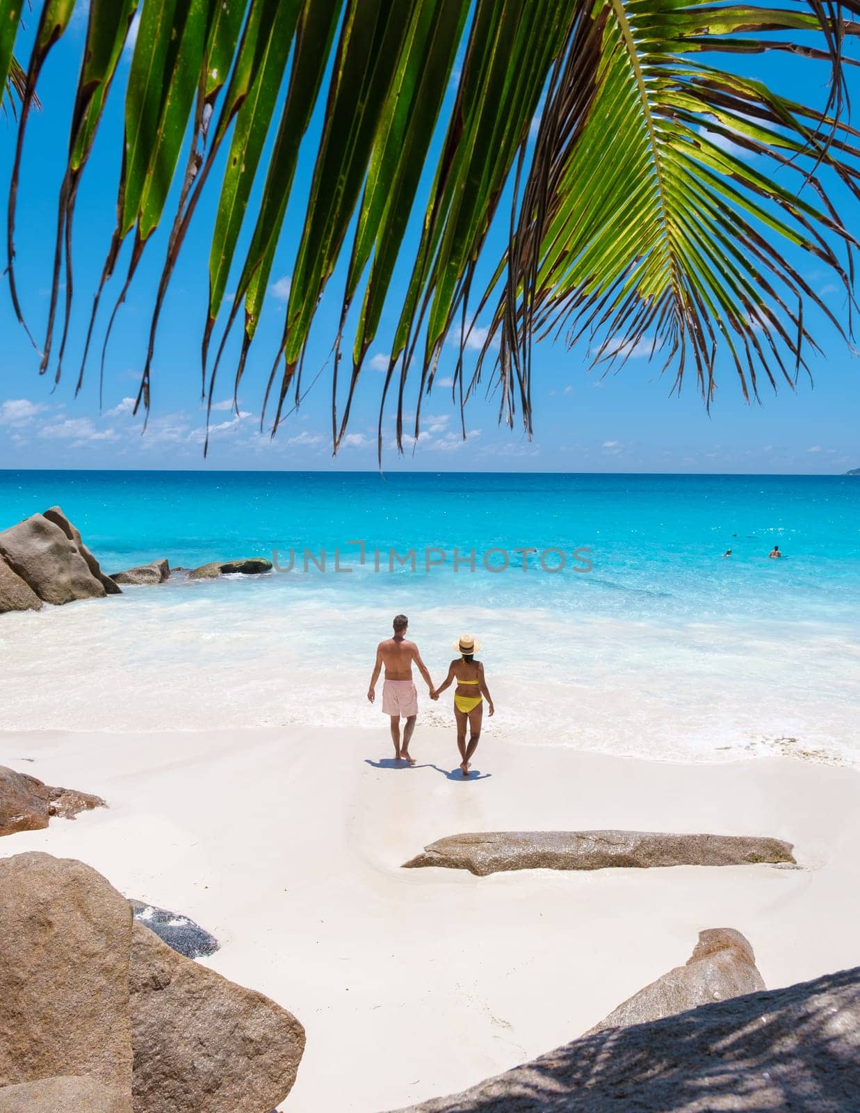 Anse Lazio Praslin Seychelles, a young couple of men and women on a tropical beach during vacation by fokkebok