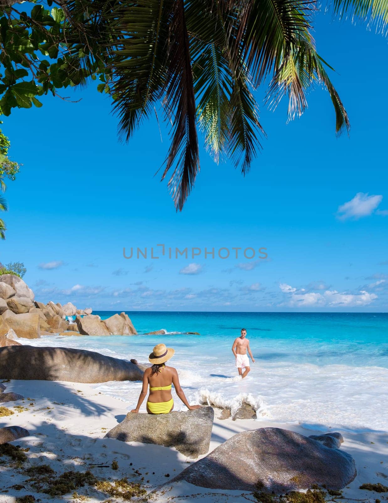 Anse Lazio Praslin Seychelles, a young couple of men and women on a tropical beach during vacation by fokkebok