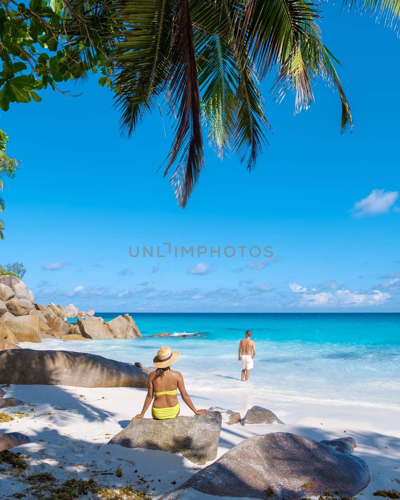 Anse Lazio Praslin Seychelles, a young couple of men and women on a tropical beach during a luxury vacation in Seychelles.