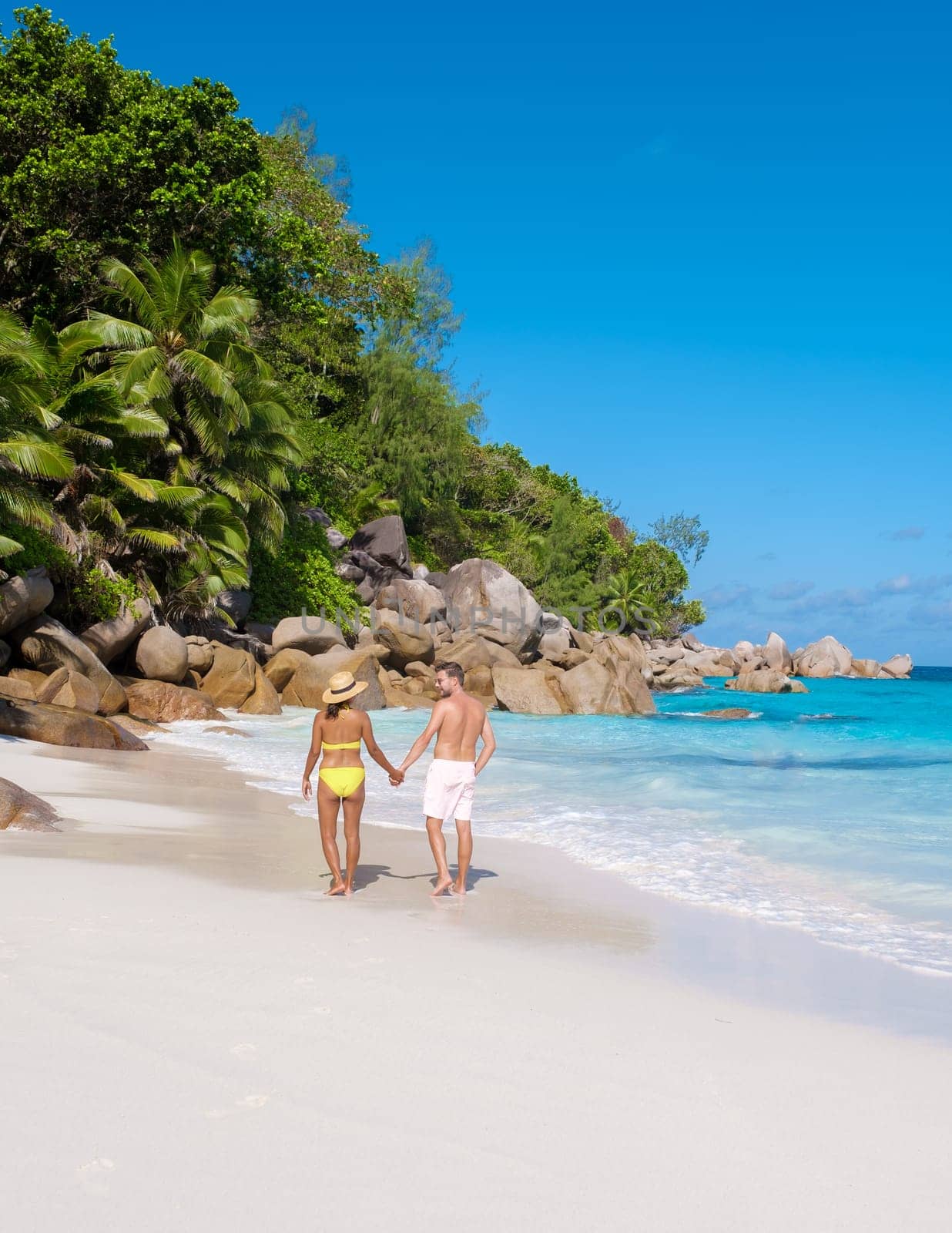 Anse Lazio Praslin Seychelles, a young couple of men and women on a tropical beach during a luxury vacation at the Seychelles. Tropical beach Anse Lazio Praslin Seychelles Islands