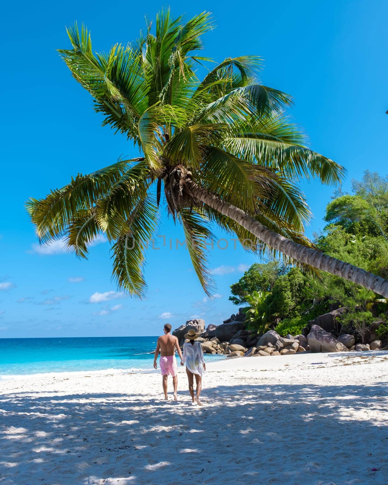 Anse Lazio Praslin Seychelles, a young couple of men and women on a tropical beach during a luxury vacation in Seychelles. Tropical beach Anse Lazio Praslin Seychelles Islands