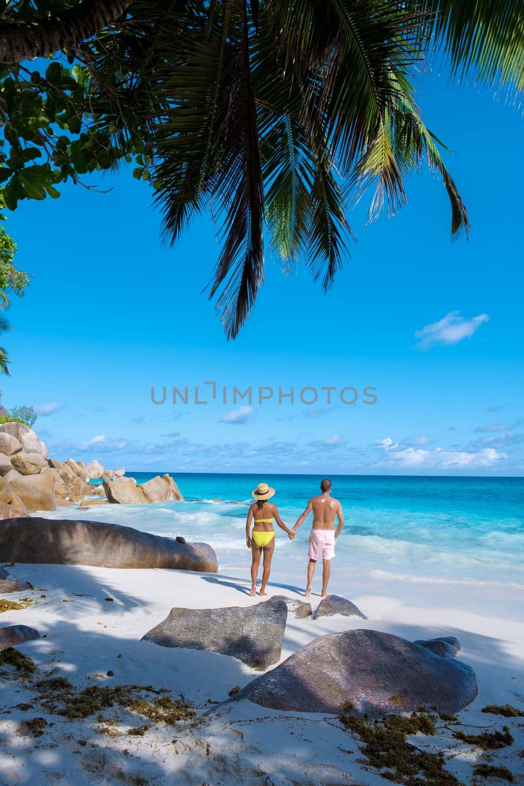 Anse Lazio Praslin Seychelles, a young couple of men and women on a tropical beach during a luxury vacation at the Seychelles. Tropical beach Anse Lazio Praslin Seychelles Islands