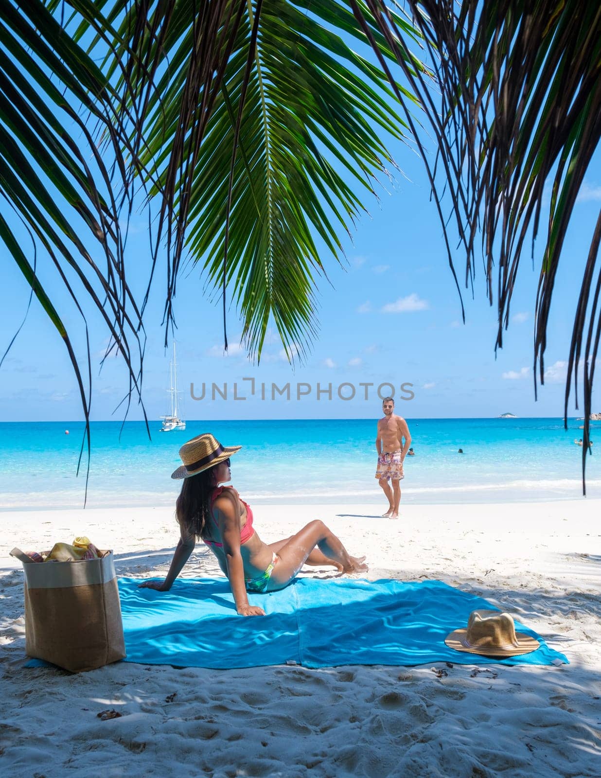 Anse Lazio Praslin Seychelles, a young couple of men and women on a tropical beach during vacation by fokkebok