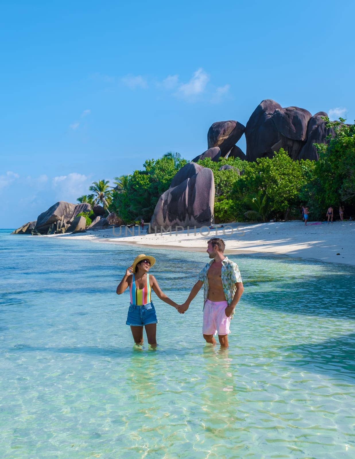 Anse Source d'Argent, La Digue Seychelles, a young couple of men and women on a tropical beach by fokkebok