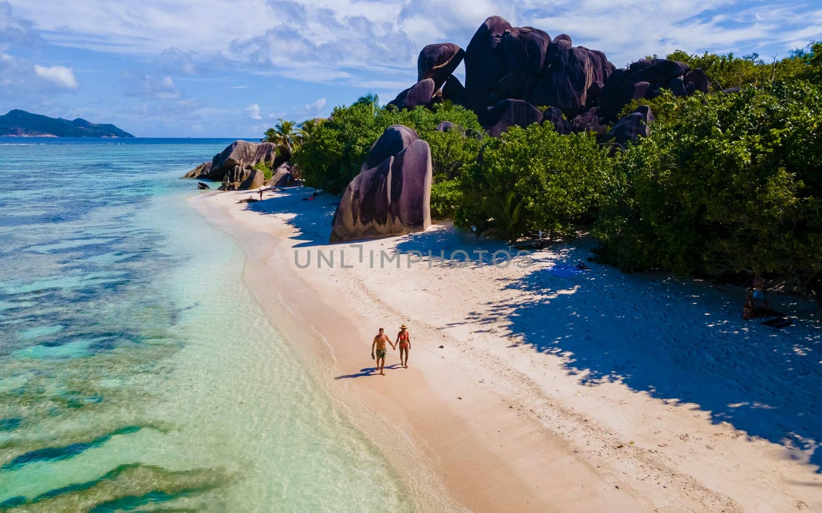 Anse Source d'Argent, La Digue Seychelles, a couple of men and women on a tropical beach during a luxury vacation in Seychelles. Tropical beach Anse Source d'Argent, La Digue Seychelles