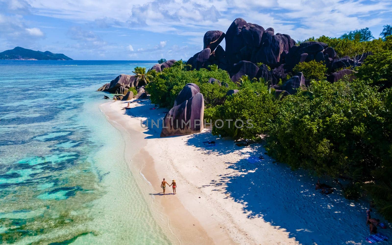 Anse Source d'Argent, La Digue Seychelles, a young couple of men and women on a tropical beach during a luxury vacation at the Seychelles.