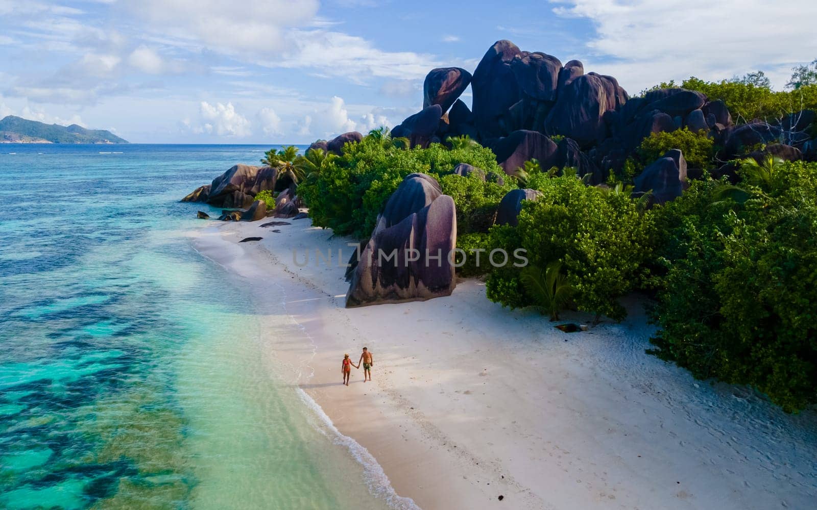 Anse Source d'Argent, La Digue Seychelles, a young couple of men and women on a tropical beach, drone aerial view of a tropical beach at the Seychelles Islands