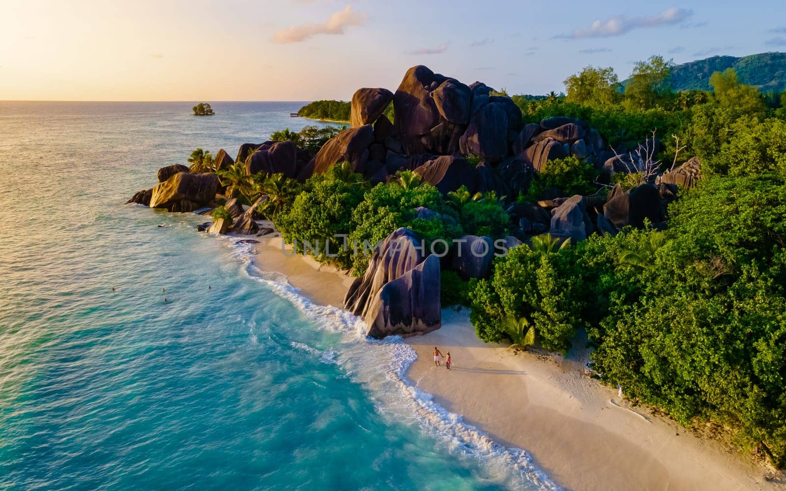 sunset at Anse Source d'Argent, La Digue Seychelles, a young couple of men and women on a tropical beach during a luxury vacation in Seychelles. Tropical beach Anse Source d'Argent, La Digue