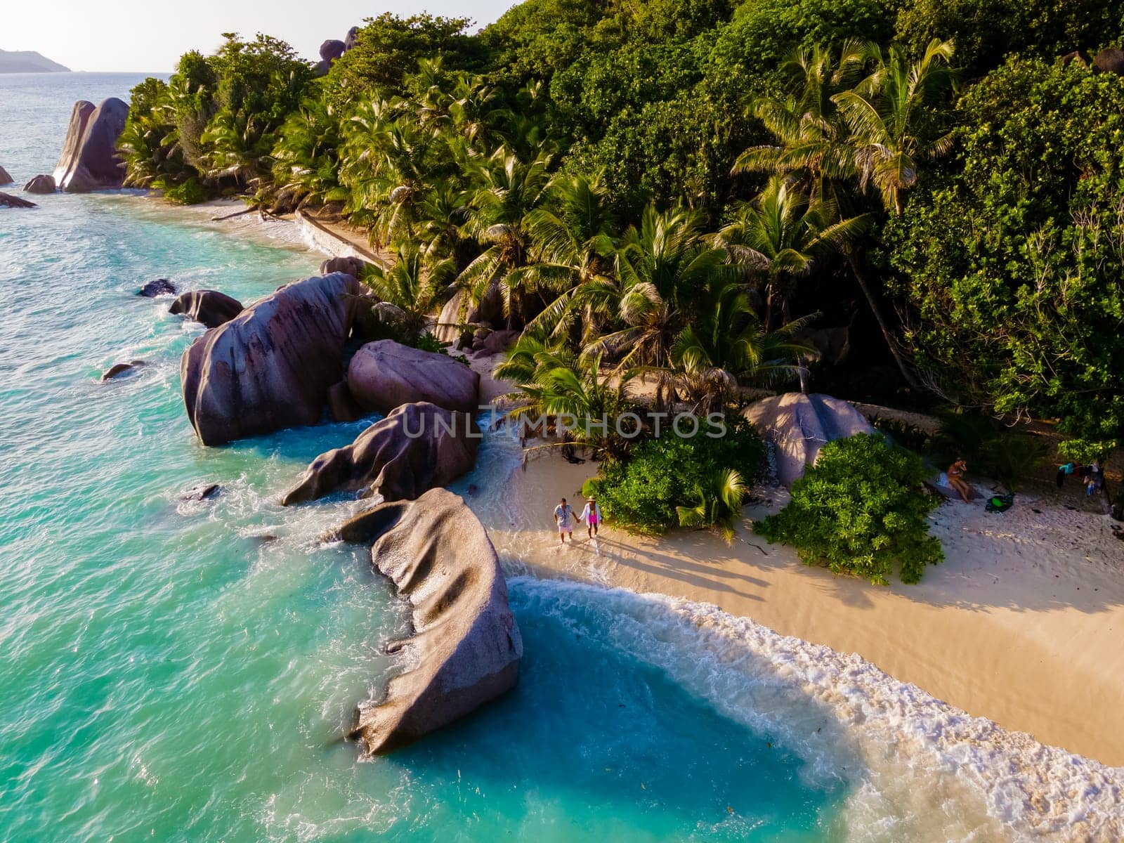 Anse Source d'Argent, La Digue Seychelles, a young couple of men and women on a tropical beach during a luxury vacation in Seychelles islands
