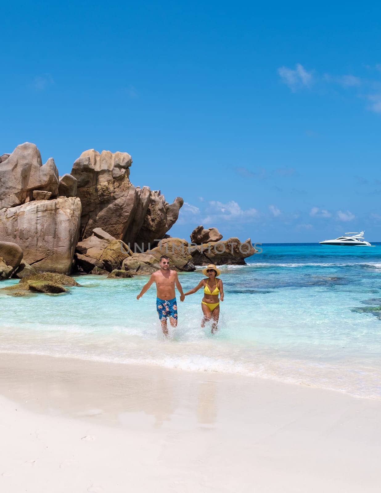 Anse Cocos La Digue Seychelles, a young couple of men and women on a tropical beach during a luxury vacation in Seychelles.
