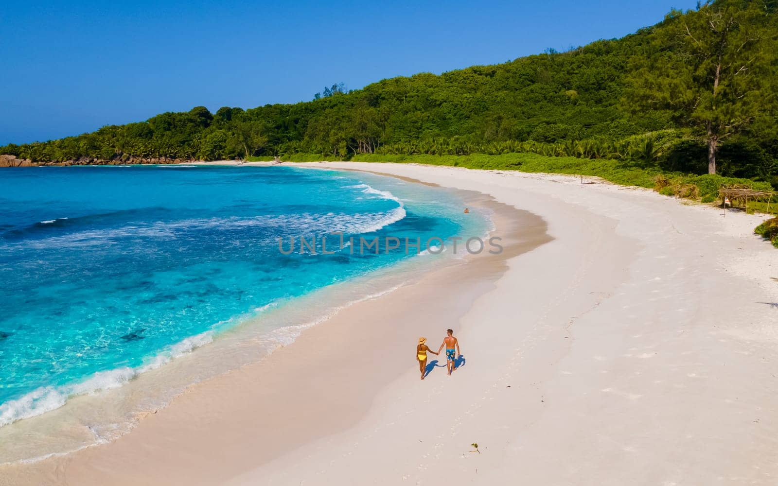 Anse Cocos La Digue Seychelles, couple of men and women on a tropical beach during a luxury vacation in Seychelles. Tropical beach Anse Cocos La Digue Seychelles.