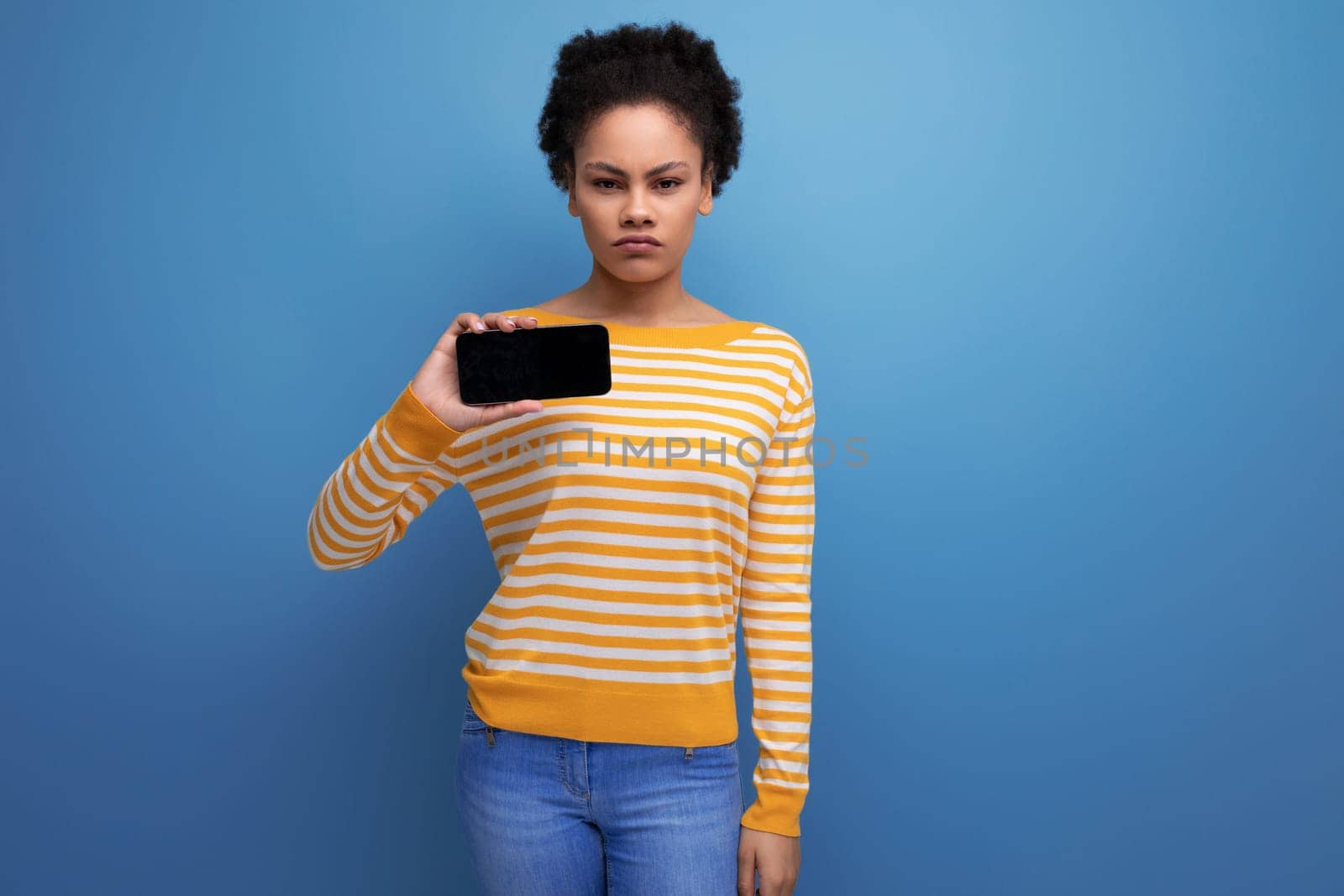 pretty latin young woman holding smartphone with mockup.