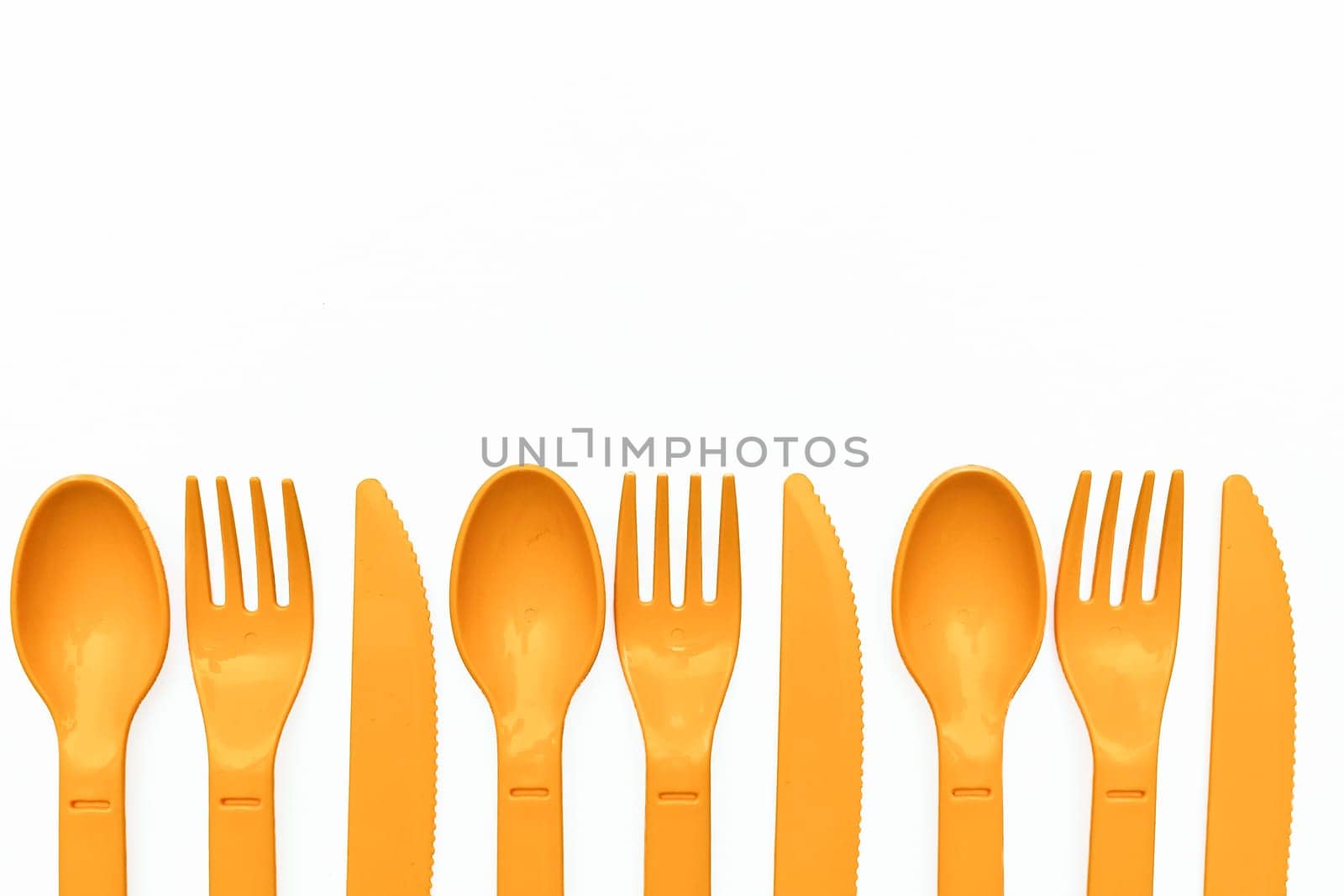 Orange plastic spoons, forks, knives for camping, isolated on white by jovani68