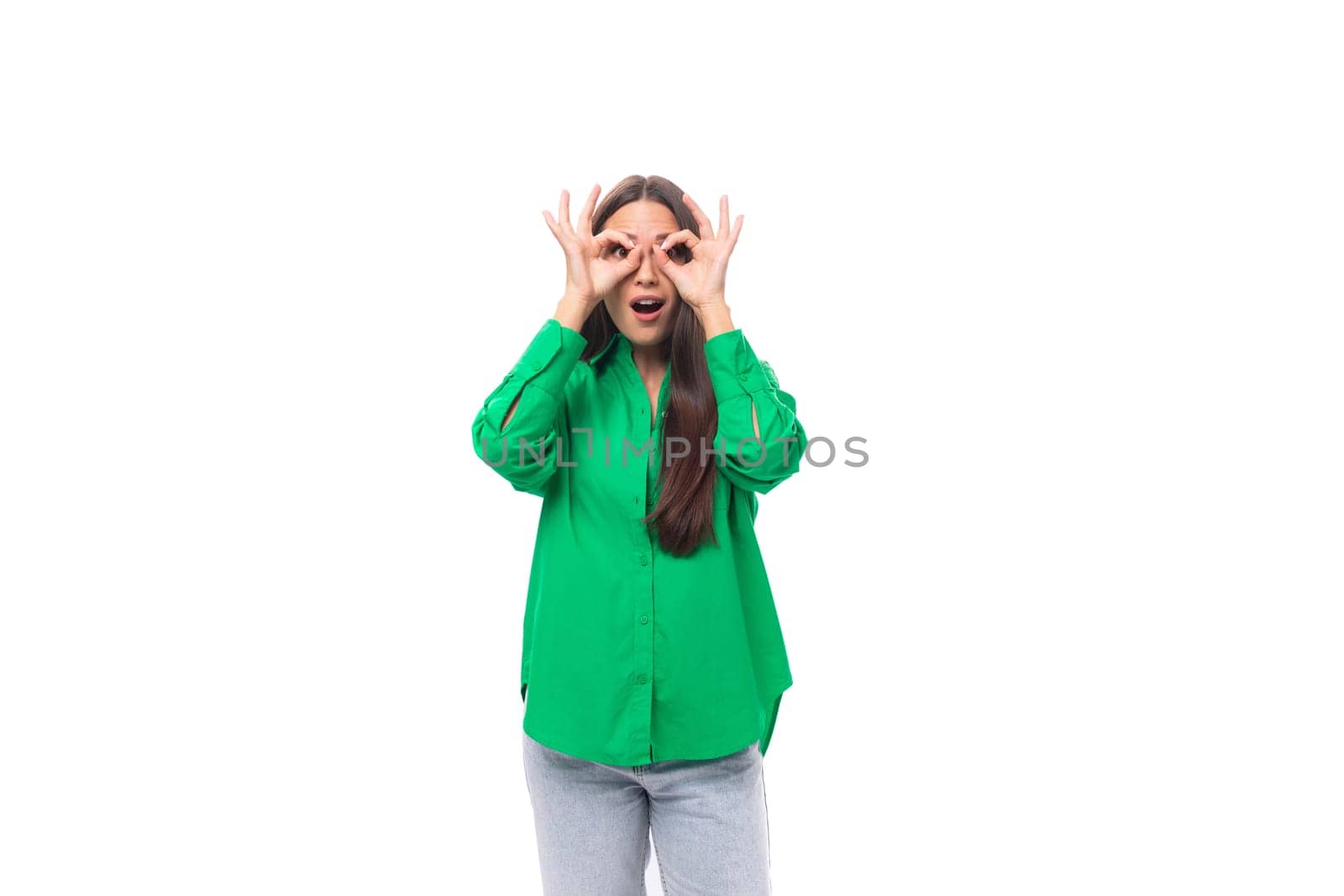 well-groomed slender brunette woman with long hair dressed in a casual green shirt makes faces by TRMK