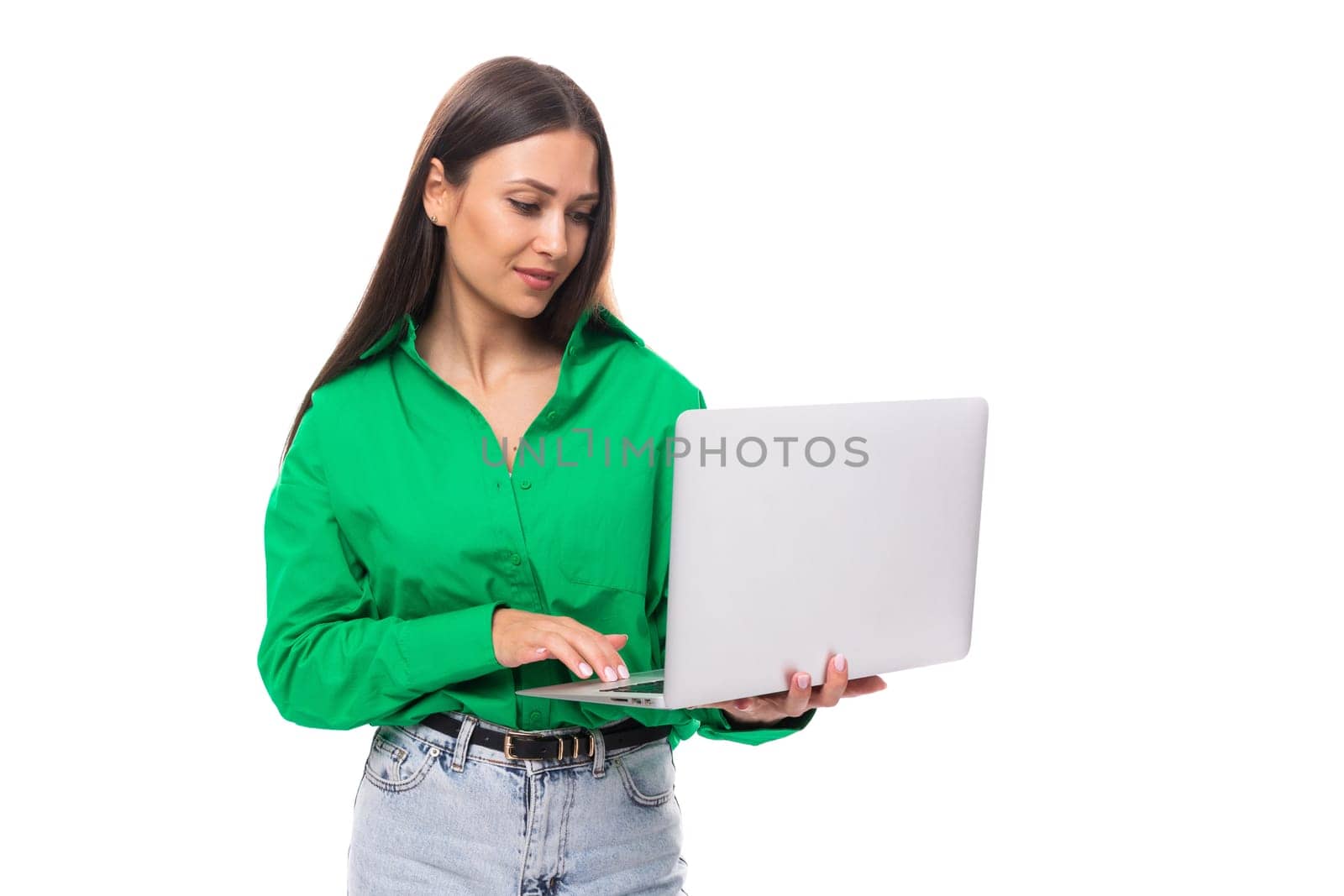 brown-eyed brunette young business lady in a green shirt with a portable computer laptop.