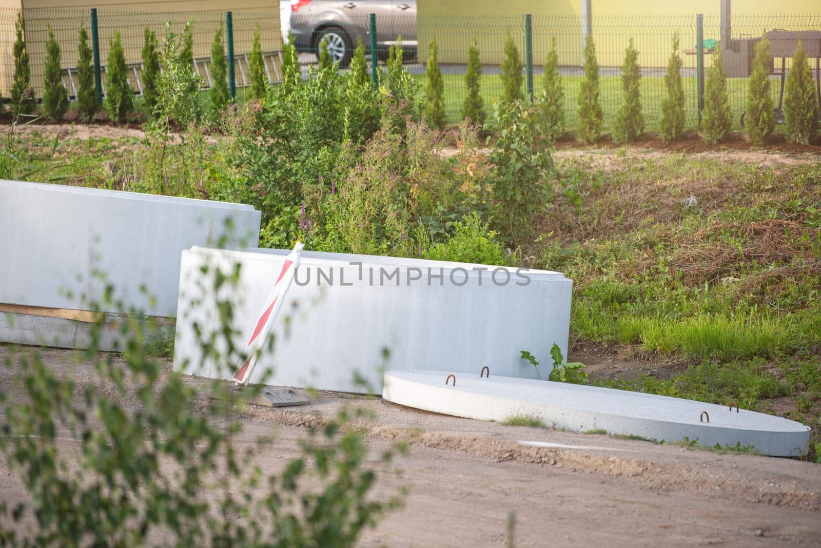 Concrete pipes on the side of the reconstructed road. Large concrete rings to collect wastewater. Reconstruction of the rainwater collection system in the city. High quality photo