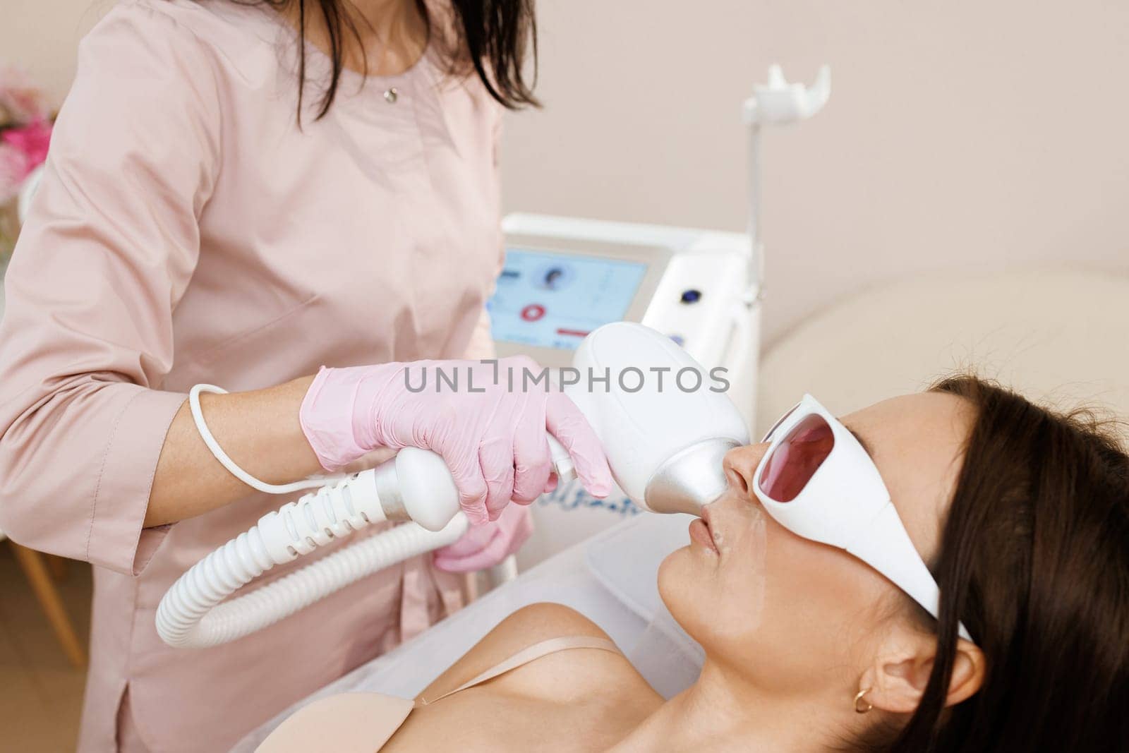 Facial laser epilation hair removal procedures. Facial rejuvenation medical correction. Therapist cosmetologist makes laser treatment for woman's face in SPA beauty clinic by uflypro