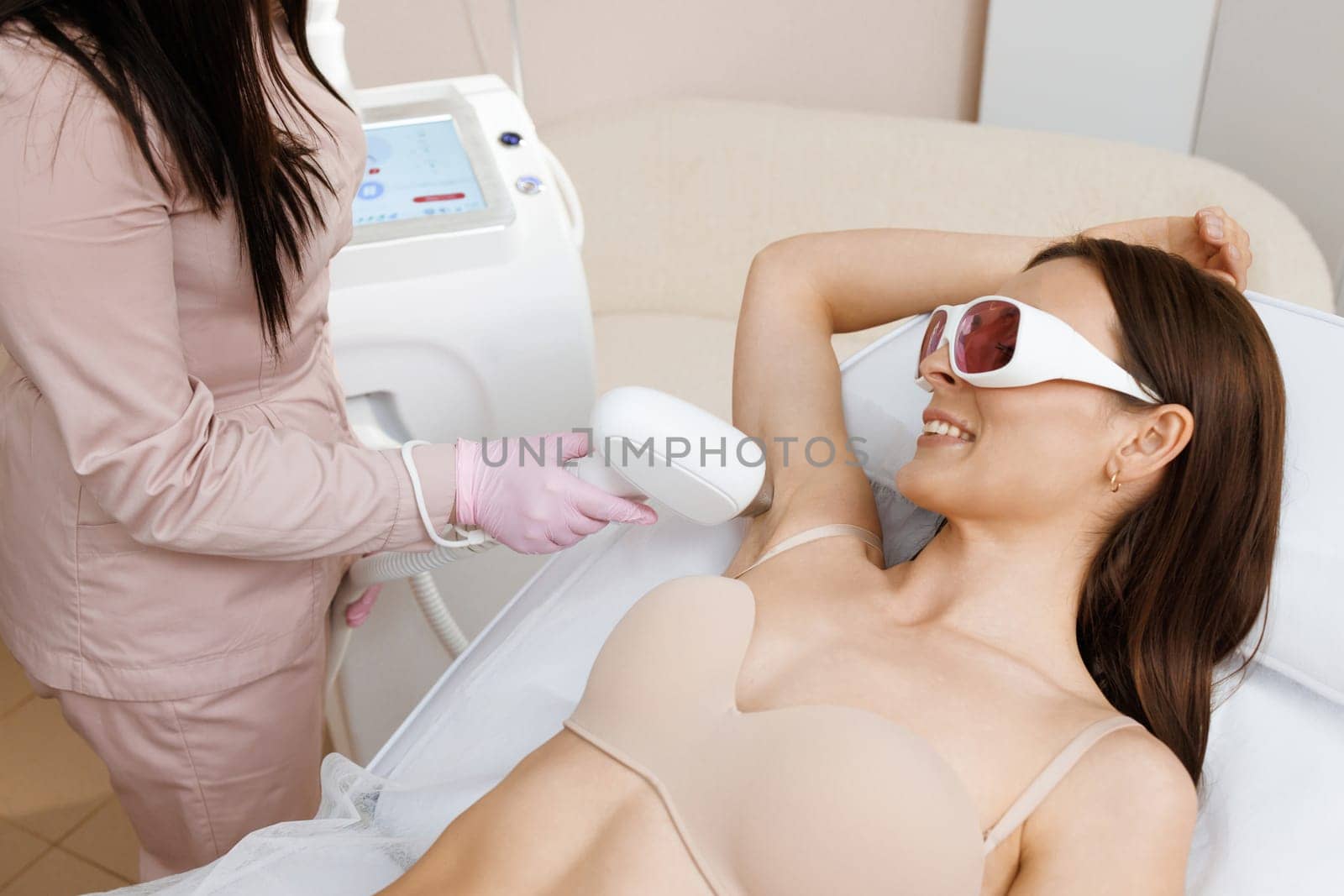 Elos epilation hair removal procedure on a womans body. Beautician doing laser rejuvenation in a beauty salon. Removing unwanted body hair. Hardware ipl cosmetology. Laser epilation by uflypro