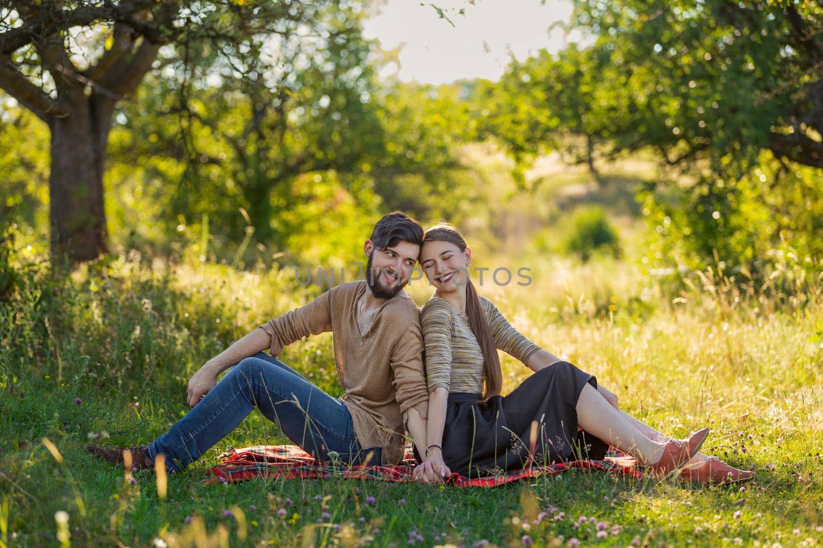 couple sitting in nature with their backs to each other