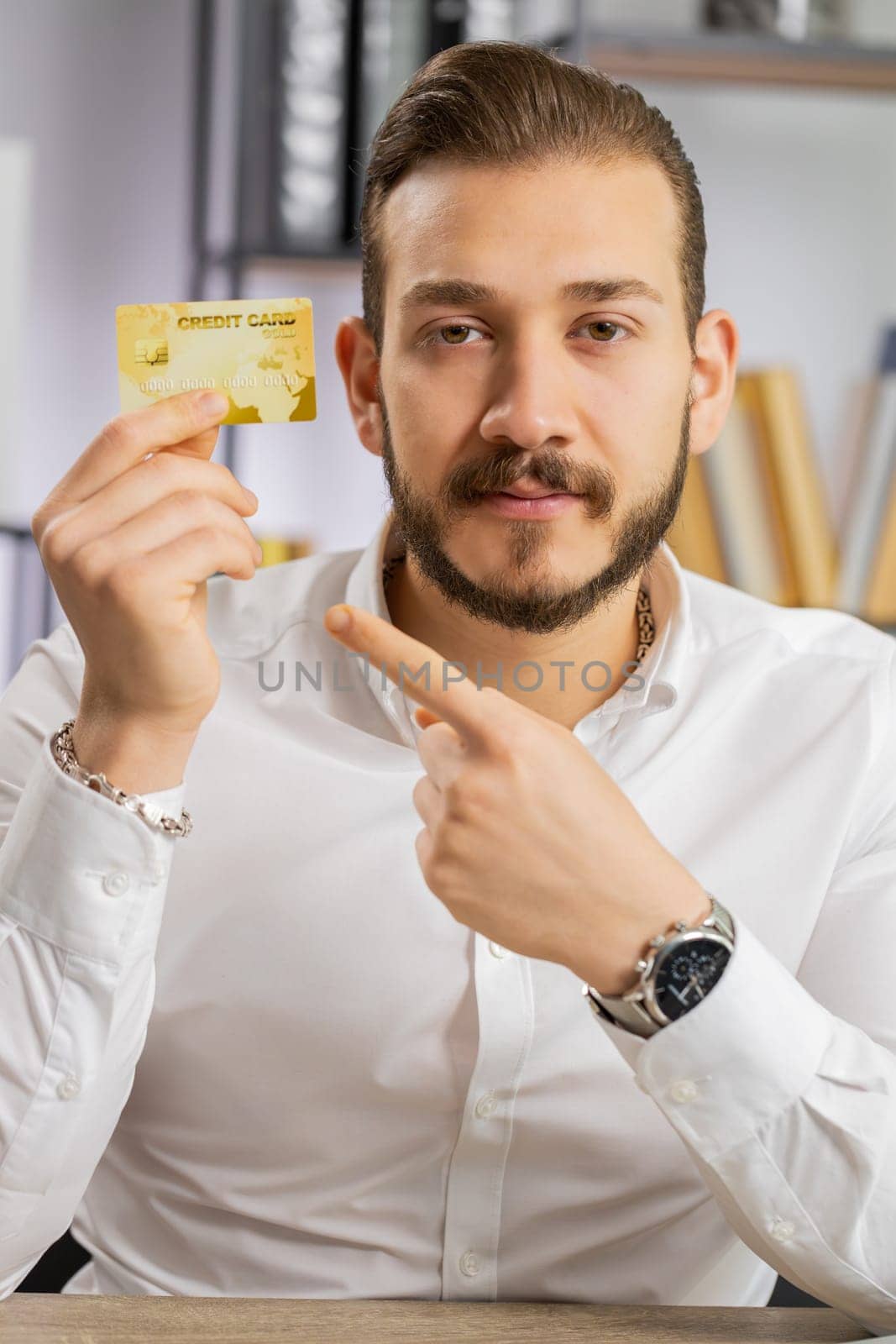 Business man showing plastic credit bank card advertising transferring money cashless, purchases online shopping, sale discount, internet order delivery purchase. Freelancer guy at office. Vertical