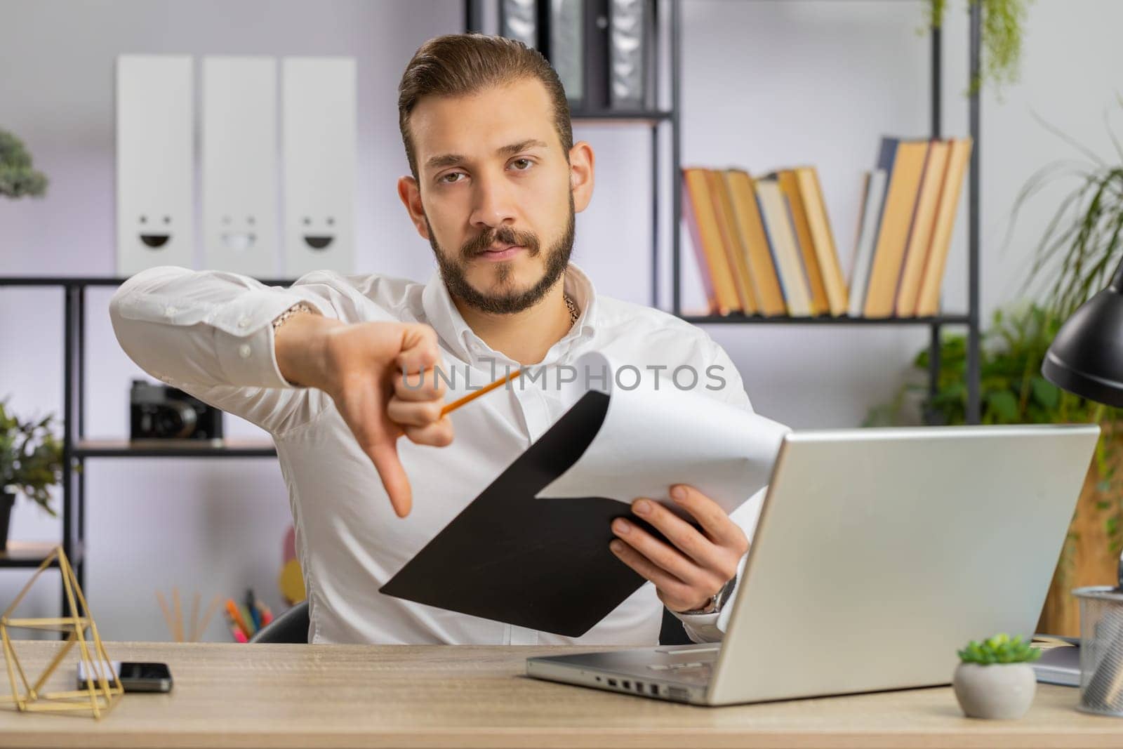 Business man reading business contract, planning project, analyzing resume, shakes finger, saying No, unsatisfied disagree, candidate with failure at office looking at camera talking, online interview
