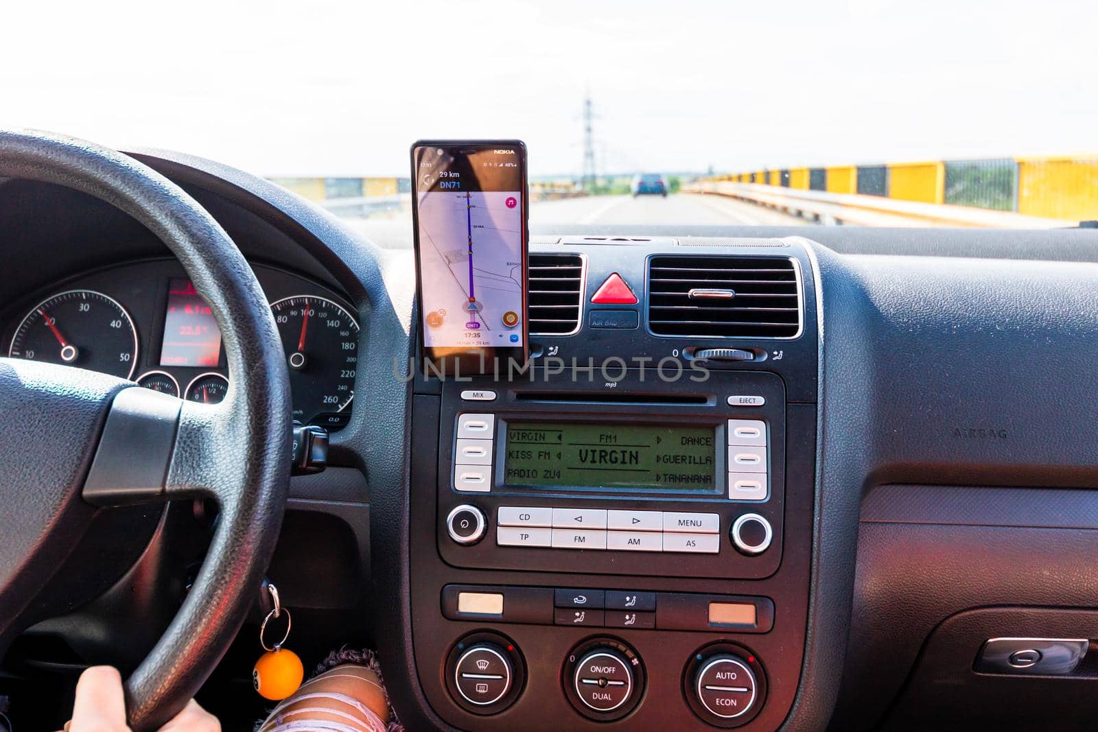 Driving and using waze maps application on smartphone on car dashboard,  Bucharest, Romania, 2021 by vladispas