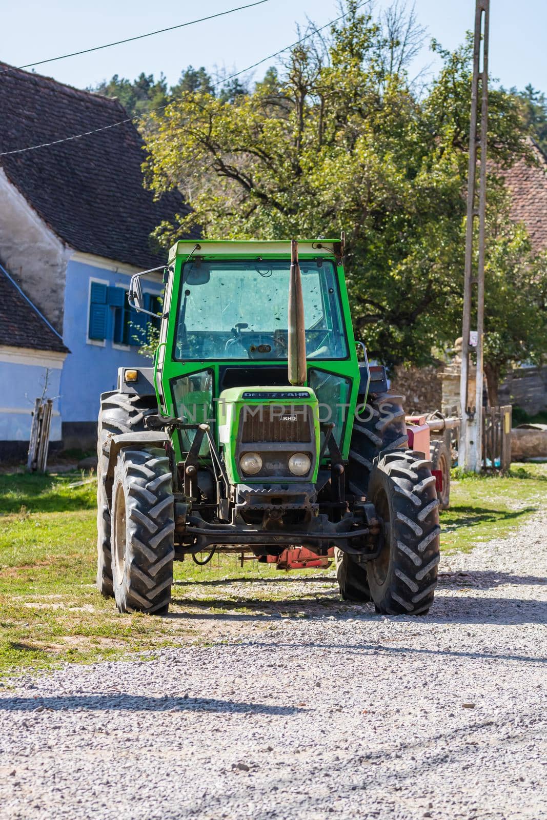 Agricultural tractor on road in Viscri, Romania, 2021 by vladispas